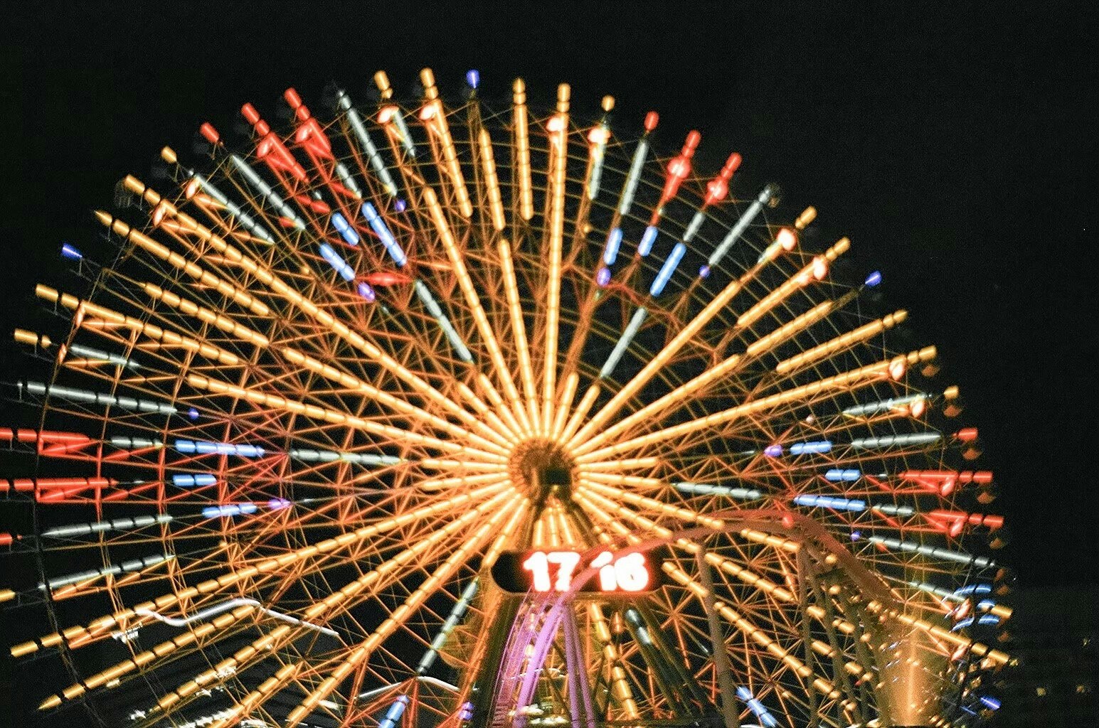 paysage de parc d’attractions la nuit, lumières de grande roue en rayons