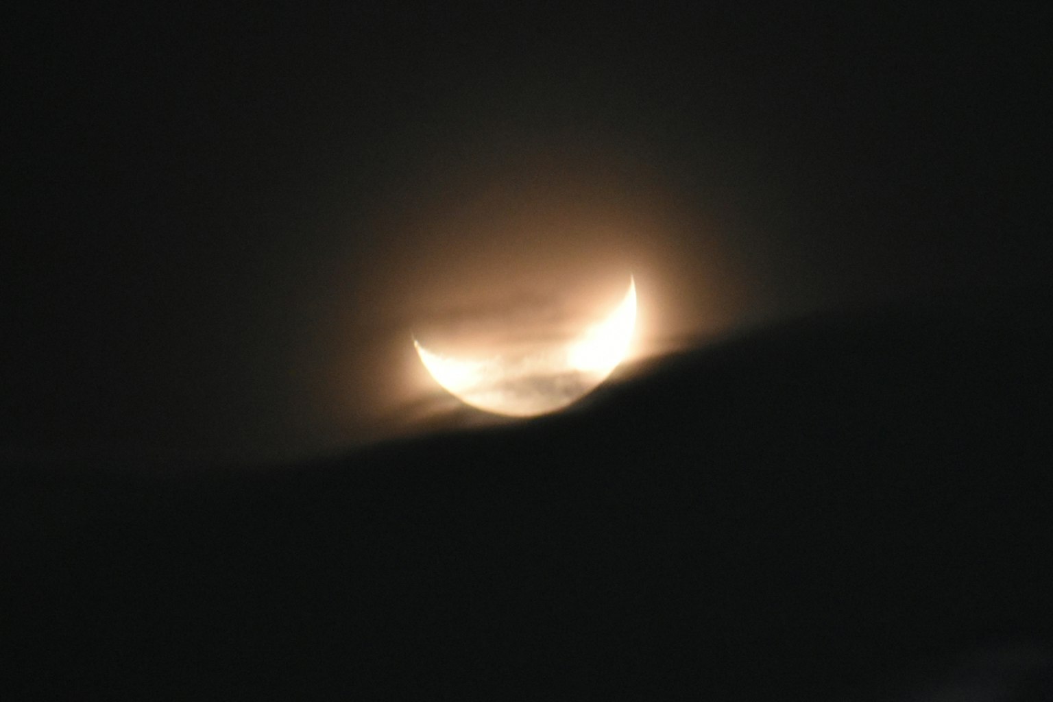 A crescent moon glowing softly against a dark background