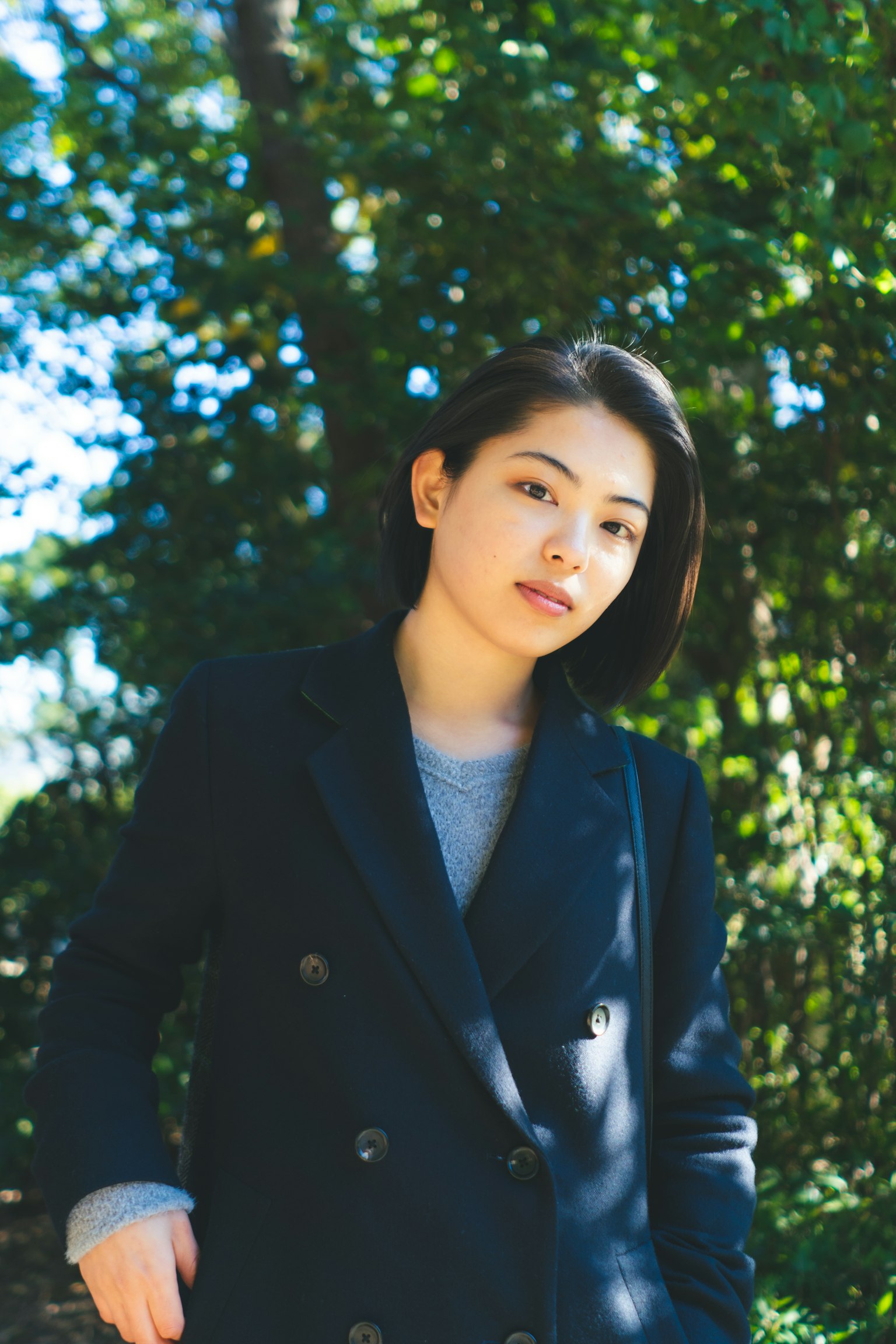黑色外套女性的肖像，背景为绿色