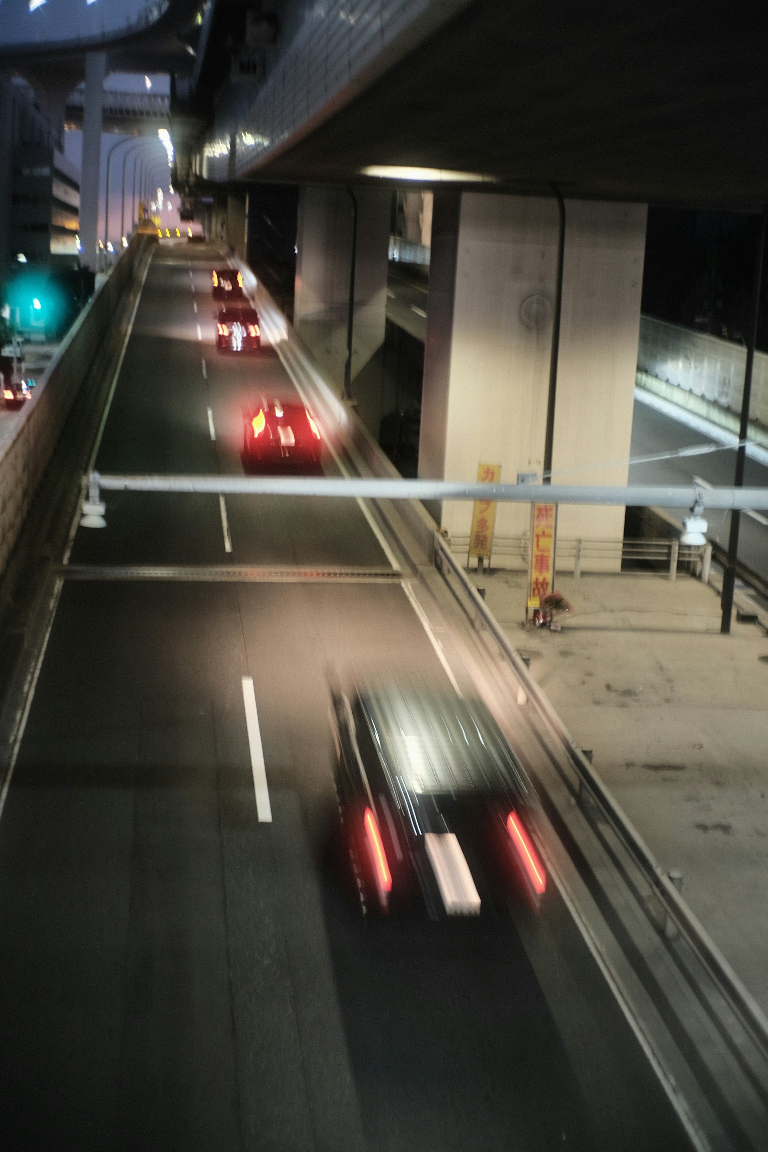 Flow of cars on a city highway at night with traffic lights
