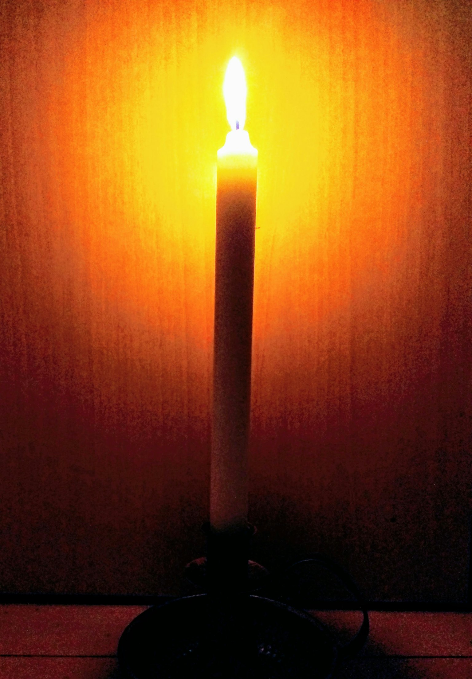 Eine brennende Kerze, die warmes oranges Licht ausstrahlt
