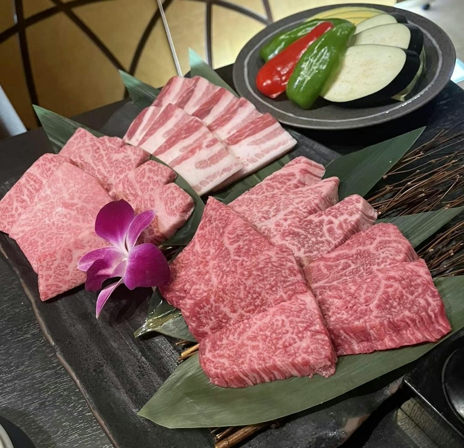 美丽的和牛拼盘配紫色花朵和蔬菜
