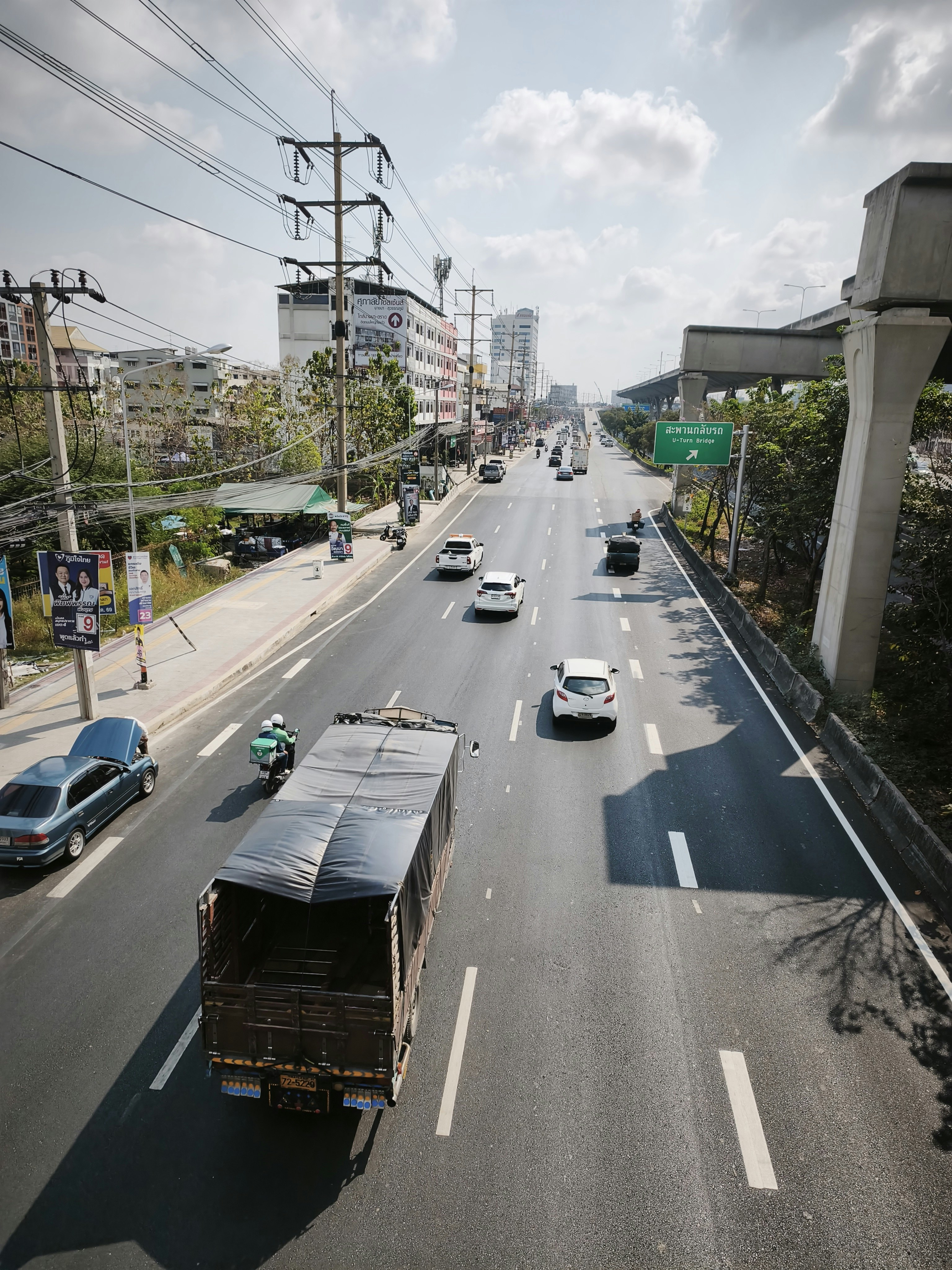 幹線道路を走るトラックと乗用車のある都市風景
