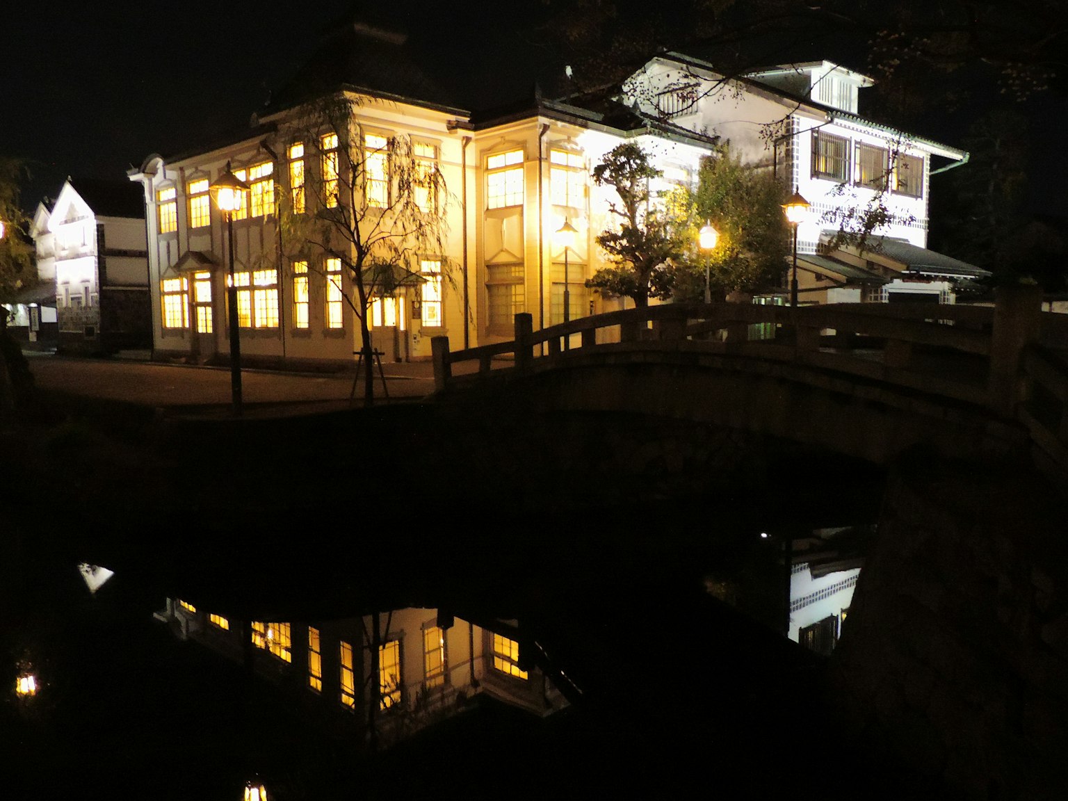 Historic building illuminated at night with reflection in water