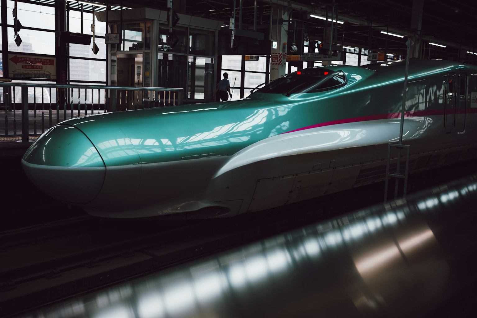 車站內的新幹線列車流線型的青綠色外觀和紅色條紋