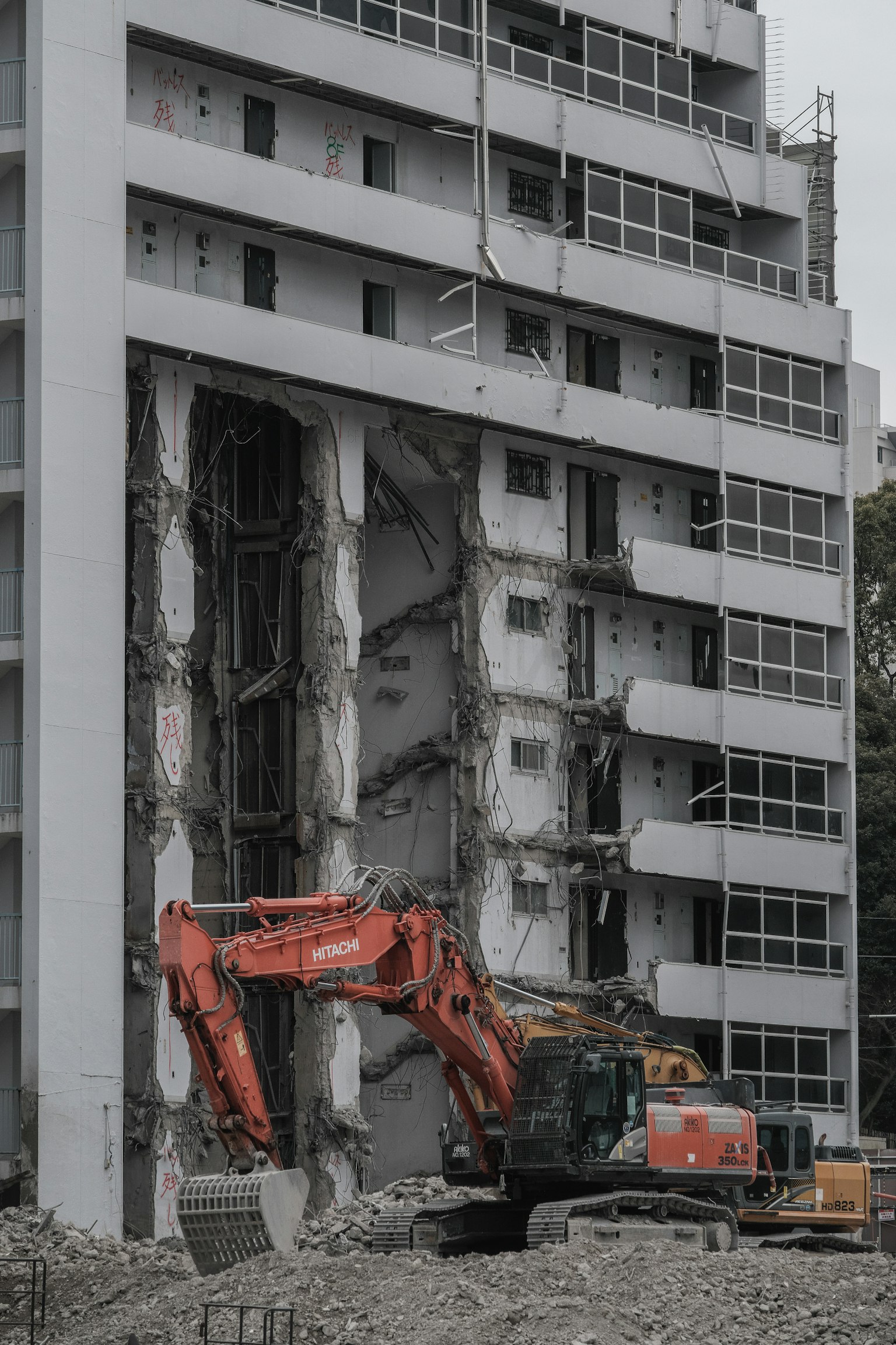 正在進行的拆除工作，重型機械和倒塌的混凝土牆