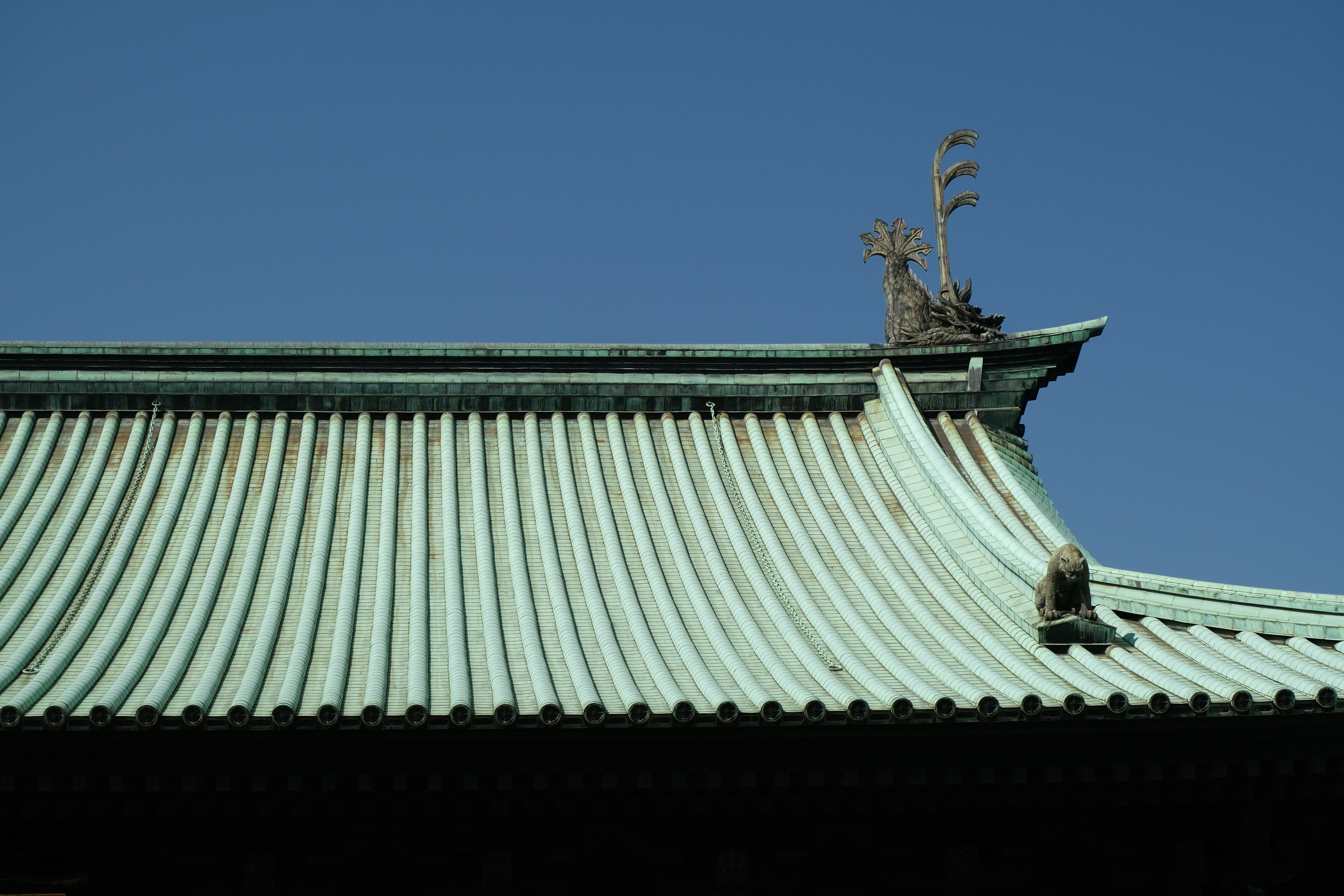 青空の下の和風の屋根と鬼瓦