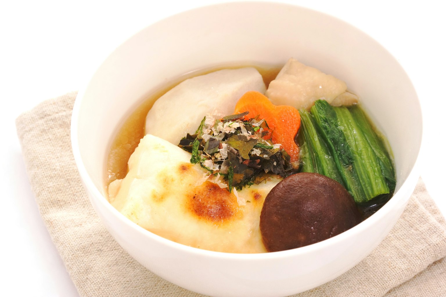 Paduan masakan Jepang disajikan dalam mangkuk putih yang menampilkan mochi lembut, telur, sayuran, dan jamur
