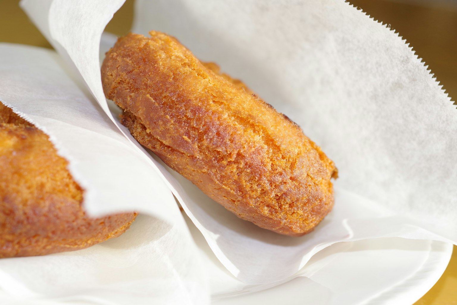 Frisch frittierte Donuts in weißem Papier eingewickelt