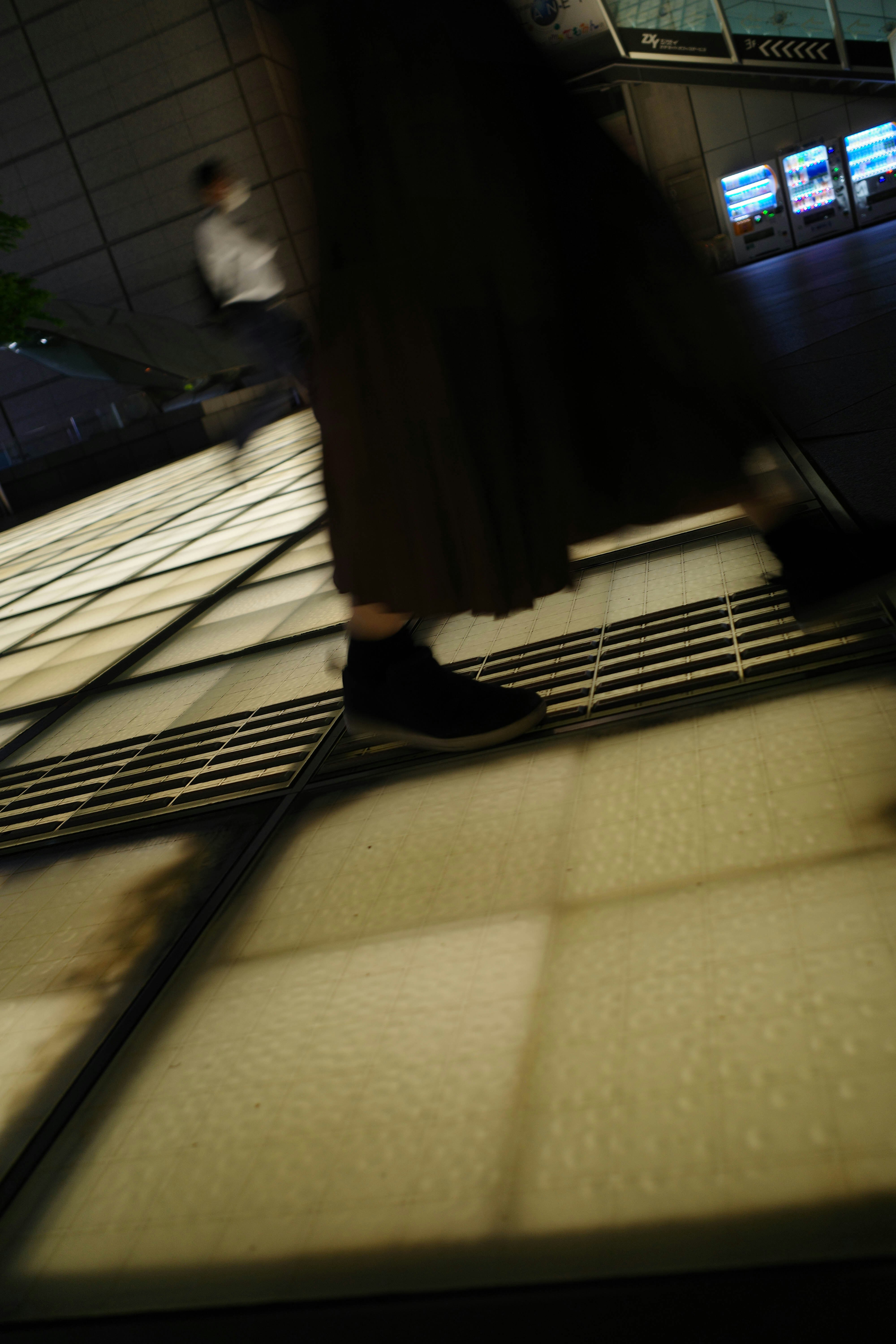 階段の手すりと床に落ちる影のある屋内通路