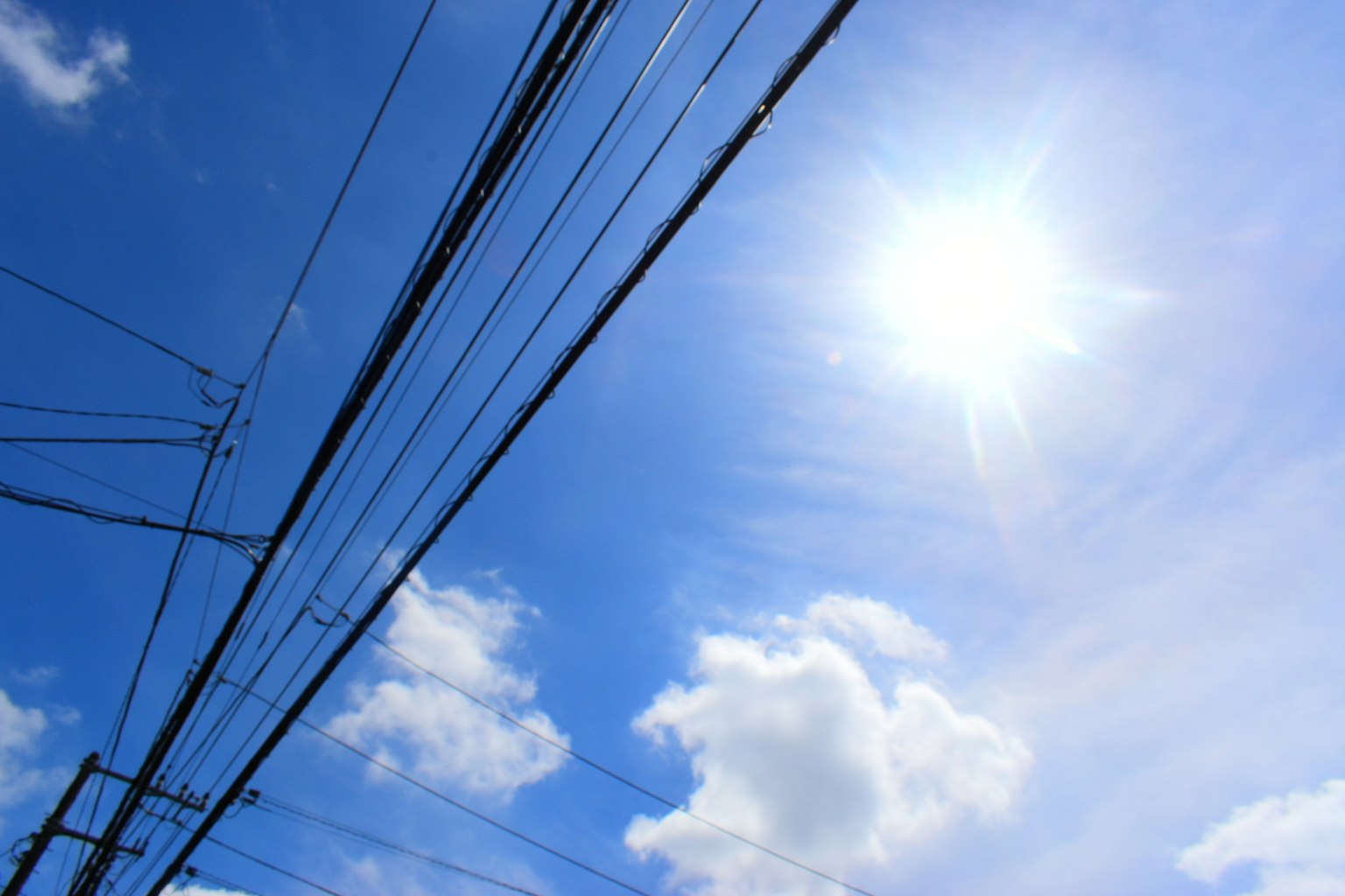 Linee elettriche contro un cielo blu luminoso e luce solare