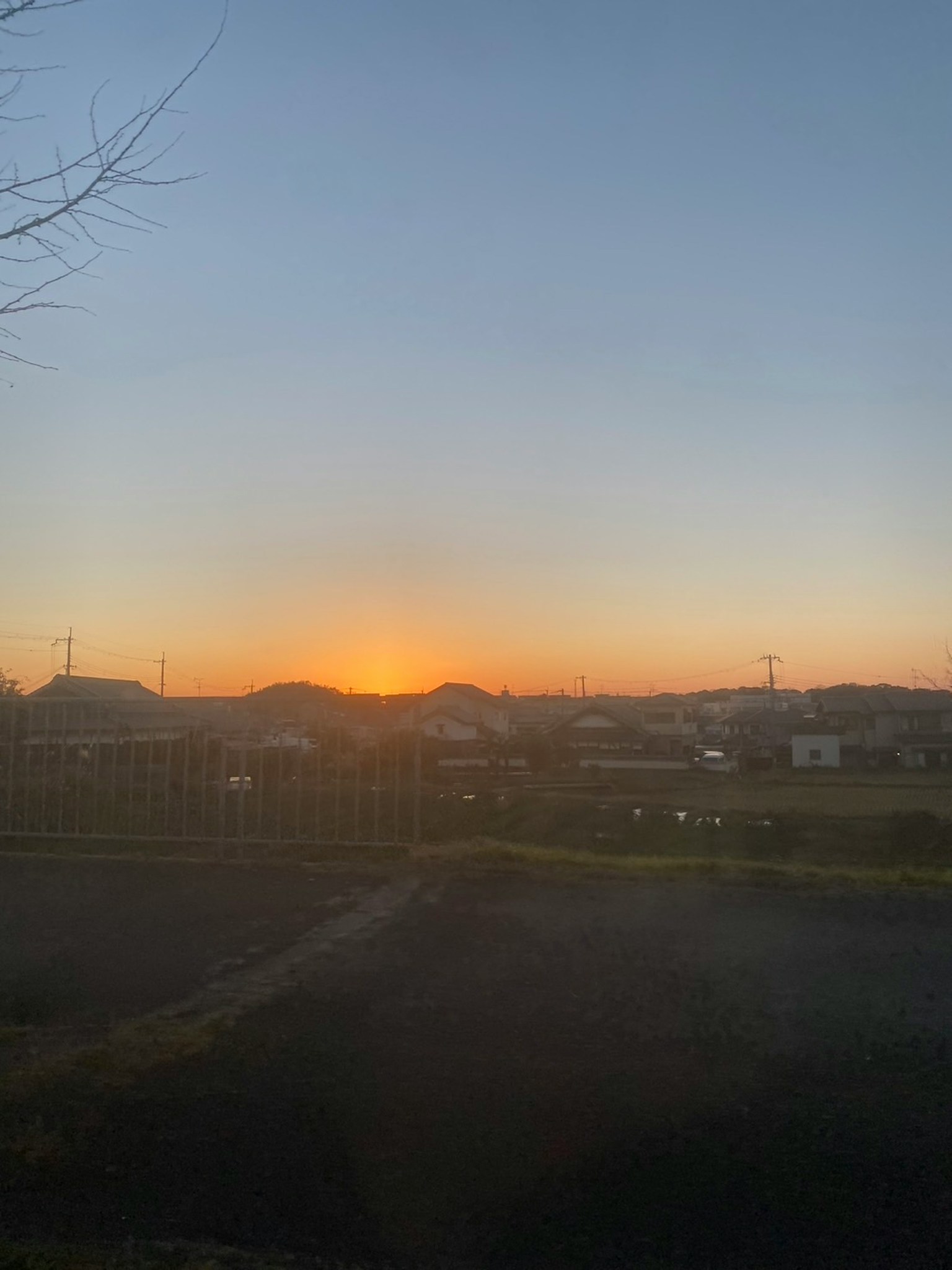 Vista del tramonto su un'area residenziale con colline in silhouette