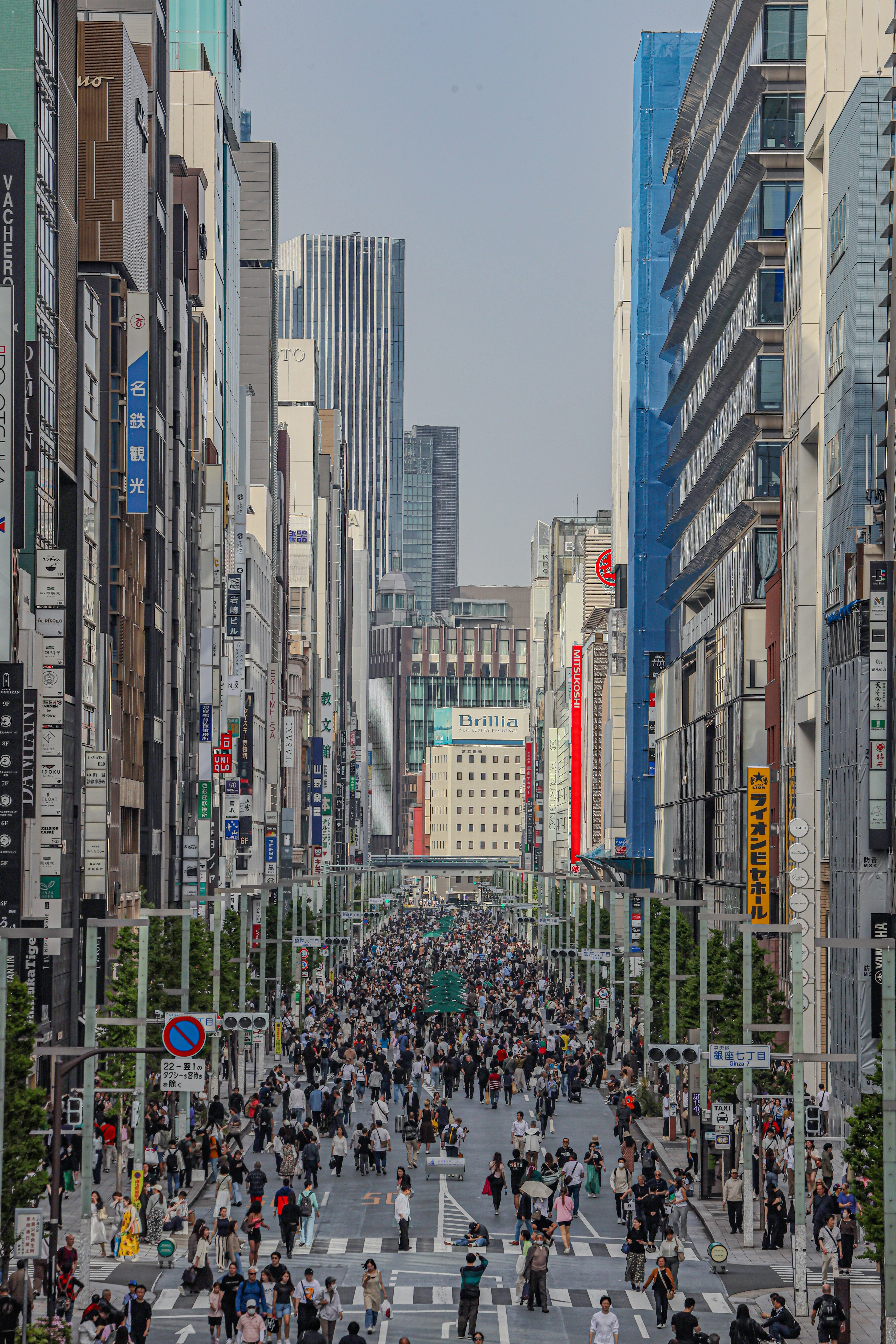 銀座の首都高沿いの大通りを行き交う人々の眺め