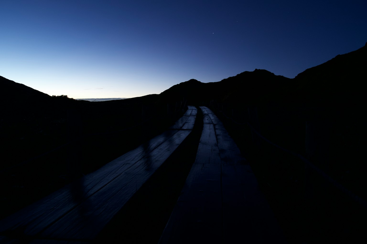 Strada di montagna all'alba con sagome e luce soffusa