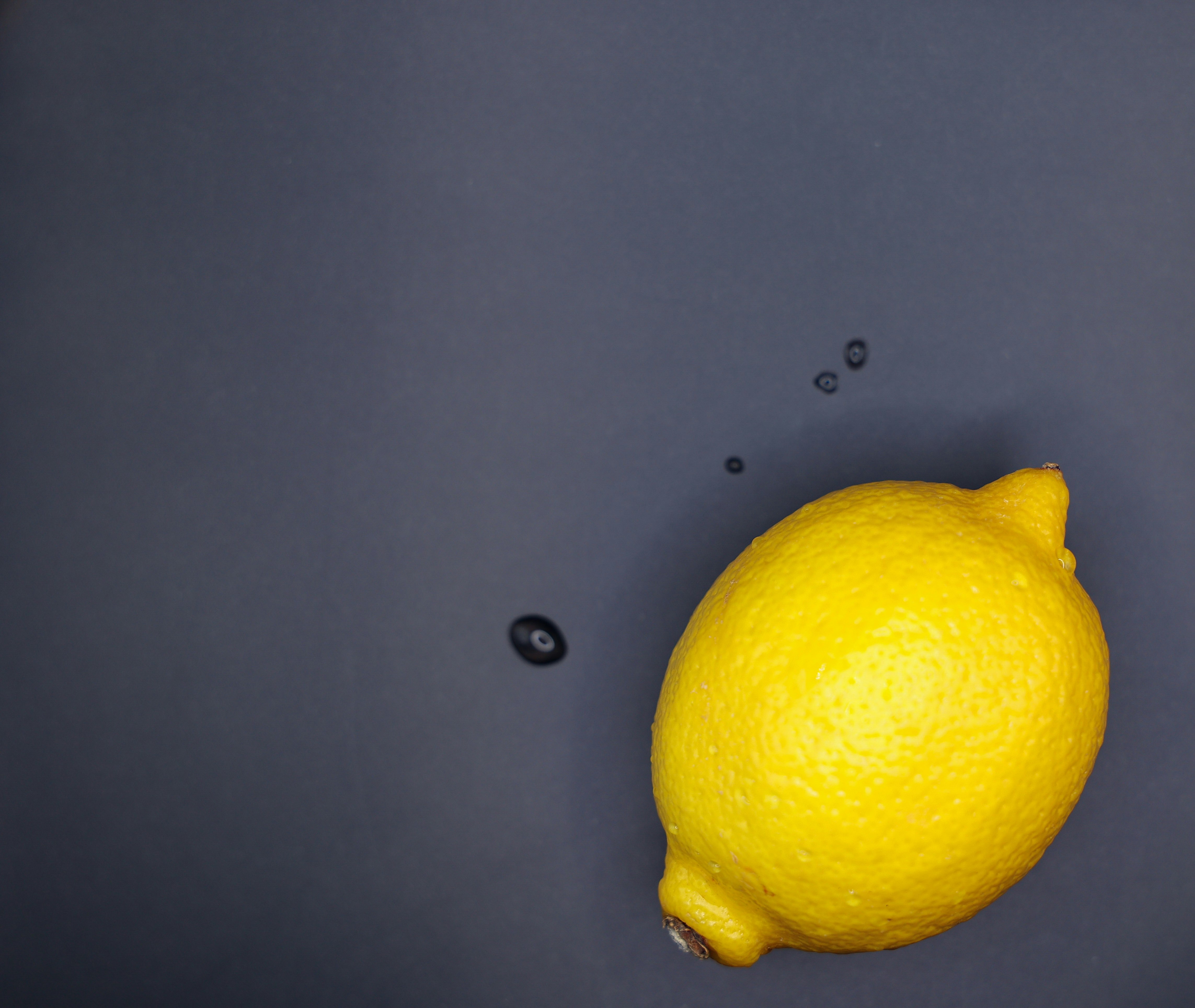 Lemon floating on a blue background with water droplets