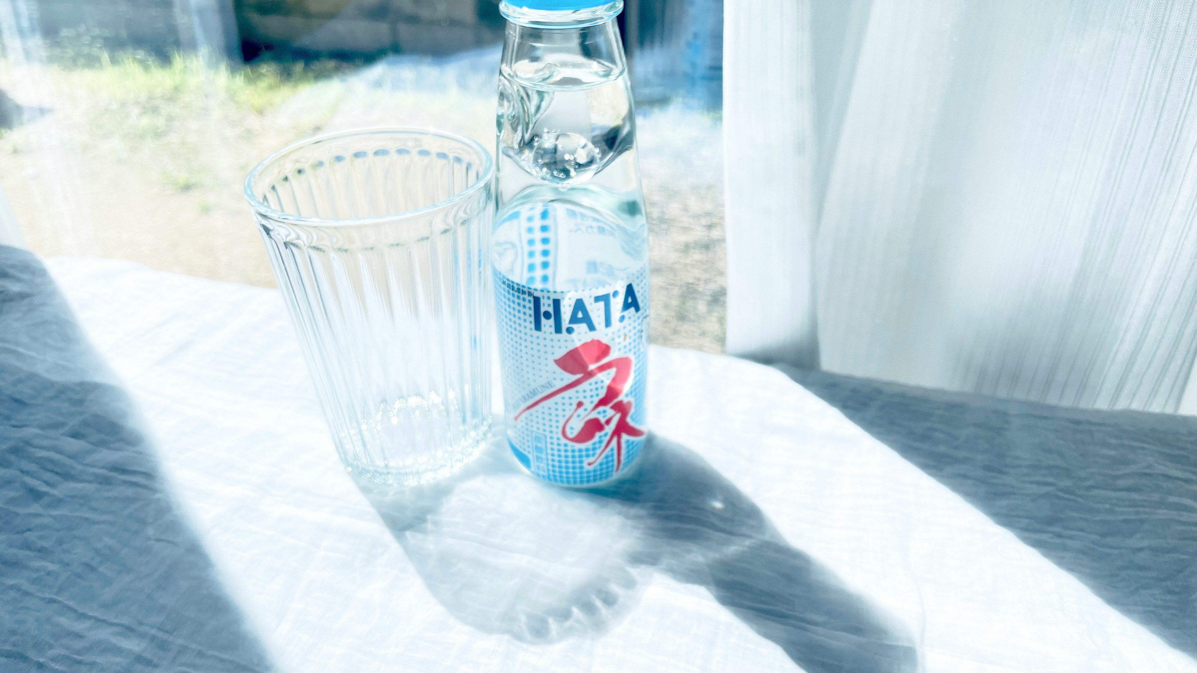 夏の思い出のラムネ瓶とグラスのあるテーブル