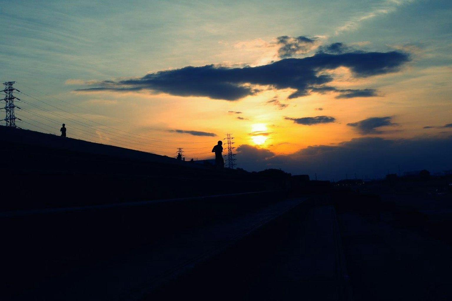 Paysage en silhouette avec ciel au coucher de soleil et lignes électriques