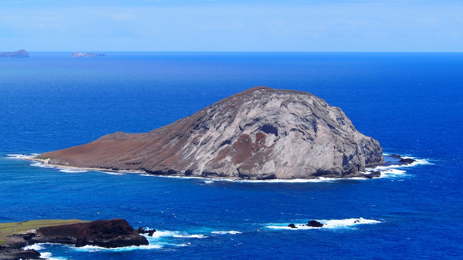 Isla pequeña aislada rodeada de mar azul