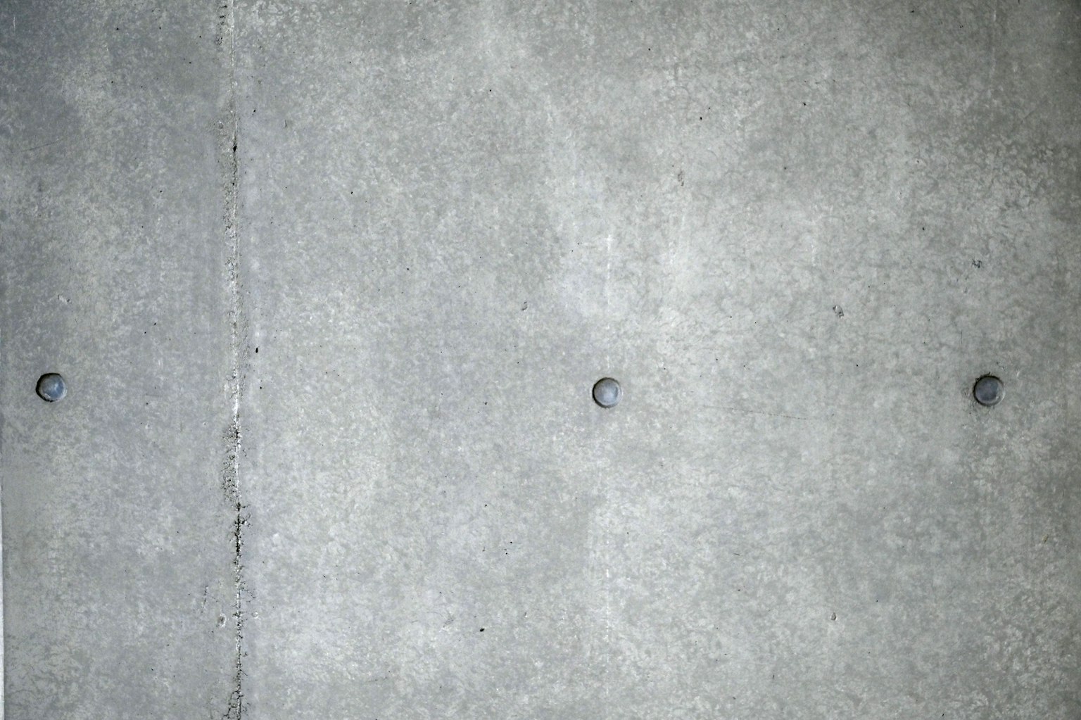 Mur en béton simple avec des boulons noirs visibles