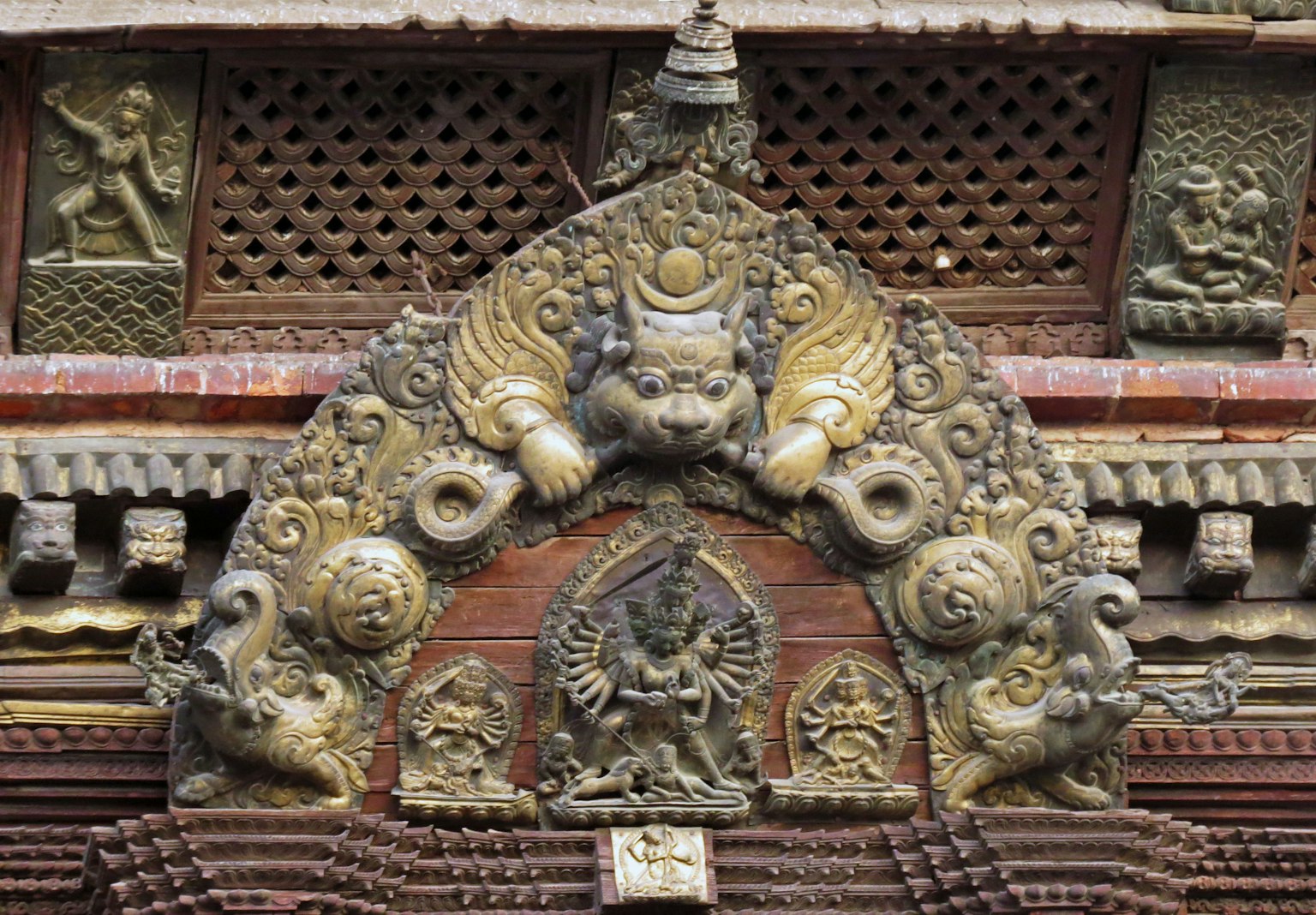 Intricately decorated temple arch featuring sculptures of deities