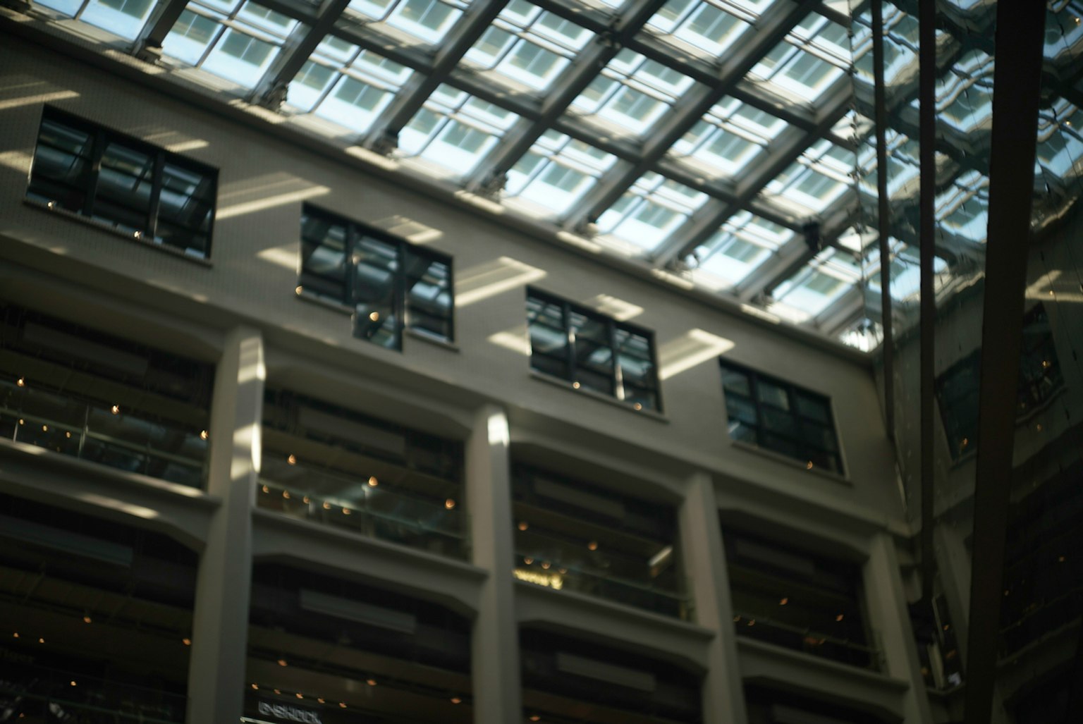 Vista interior de un edificio moderno con un techo de vidrio brillante
