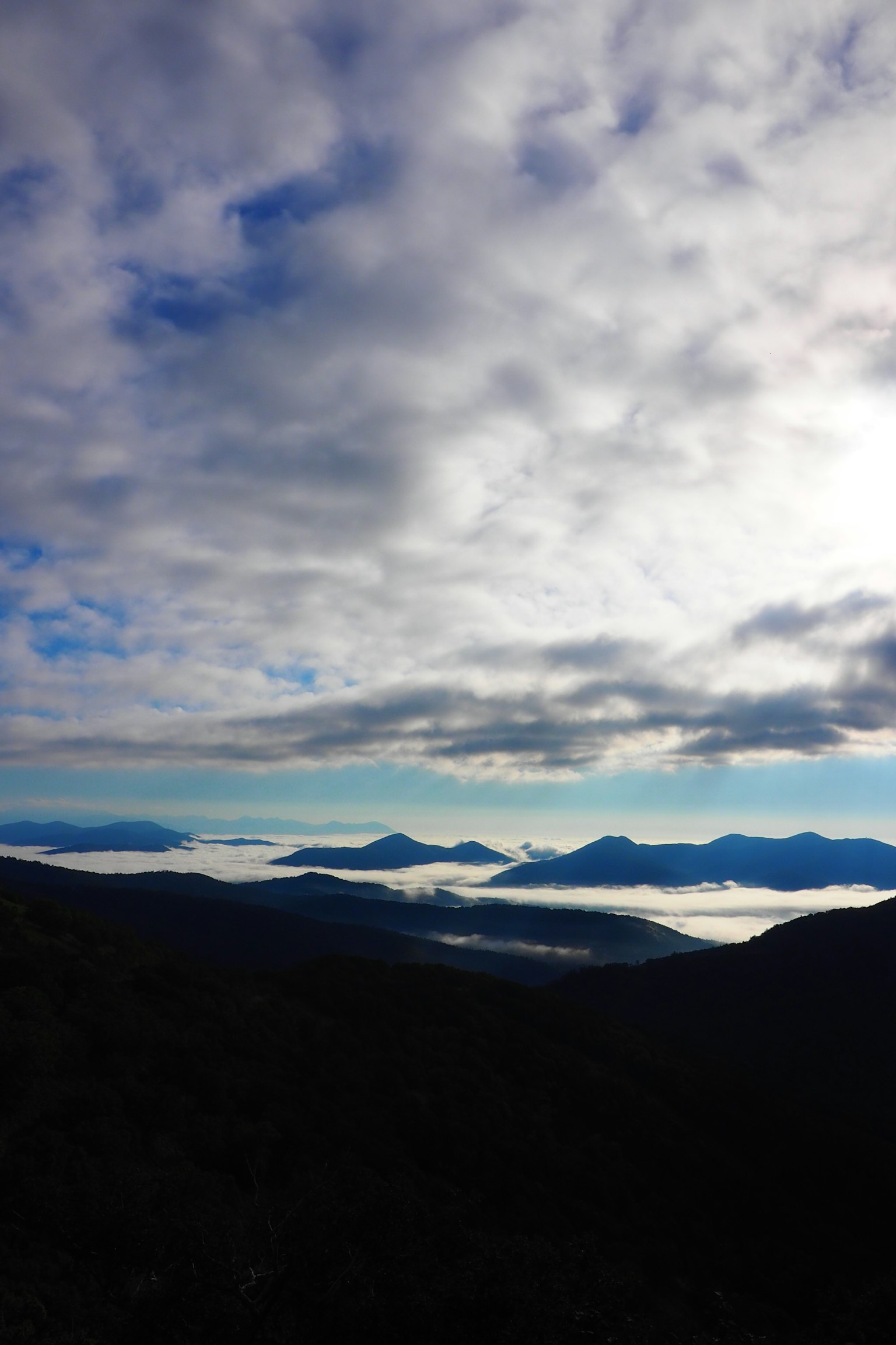 Paesaggio di montagne coperte di nebbia con cielo nuvoloso
