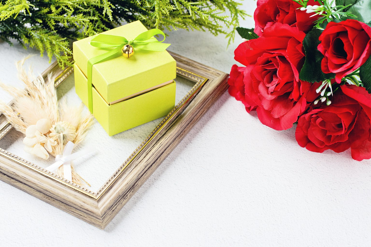 A beautiful design featuring a yellow gift box with a green ribbon and a bouquet of red roses