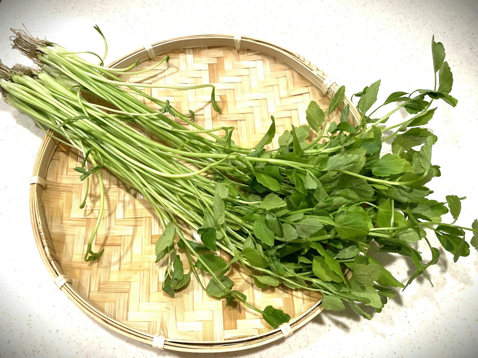 A bunch of fresh herbs on a woven basket