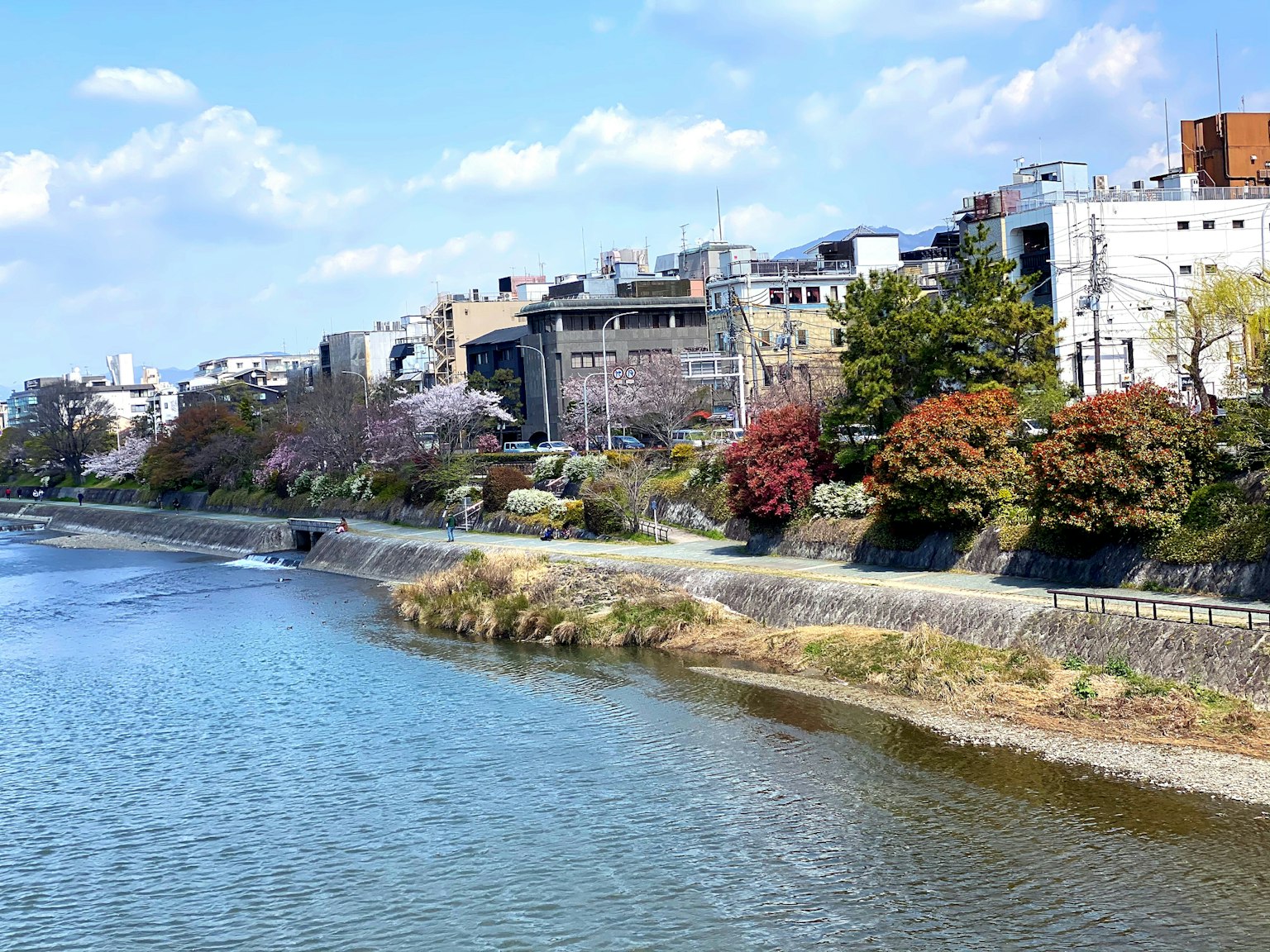 Vista escénica de un río y un paisaje urbano con cielo azul y nubes