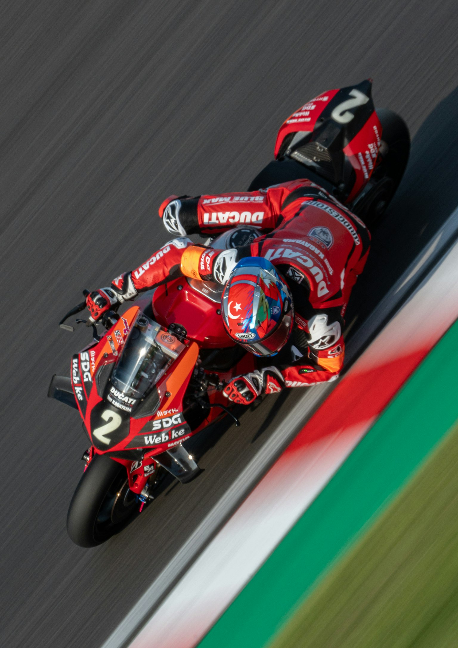 Rider on a red motorcycle leaning into a corner