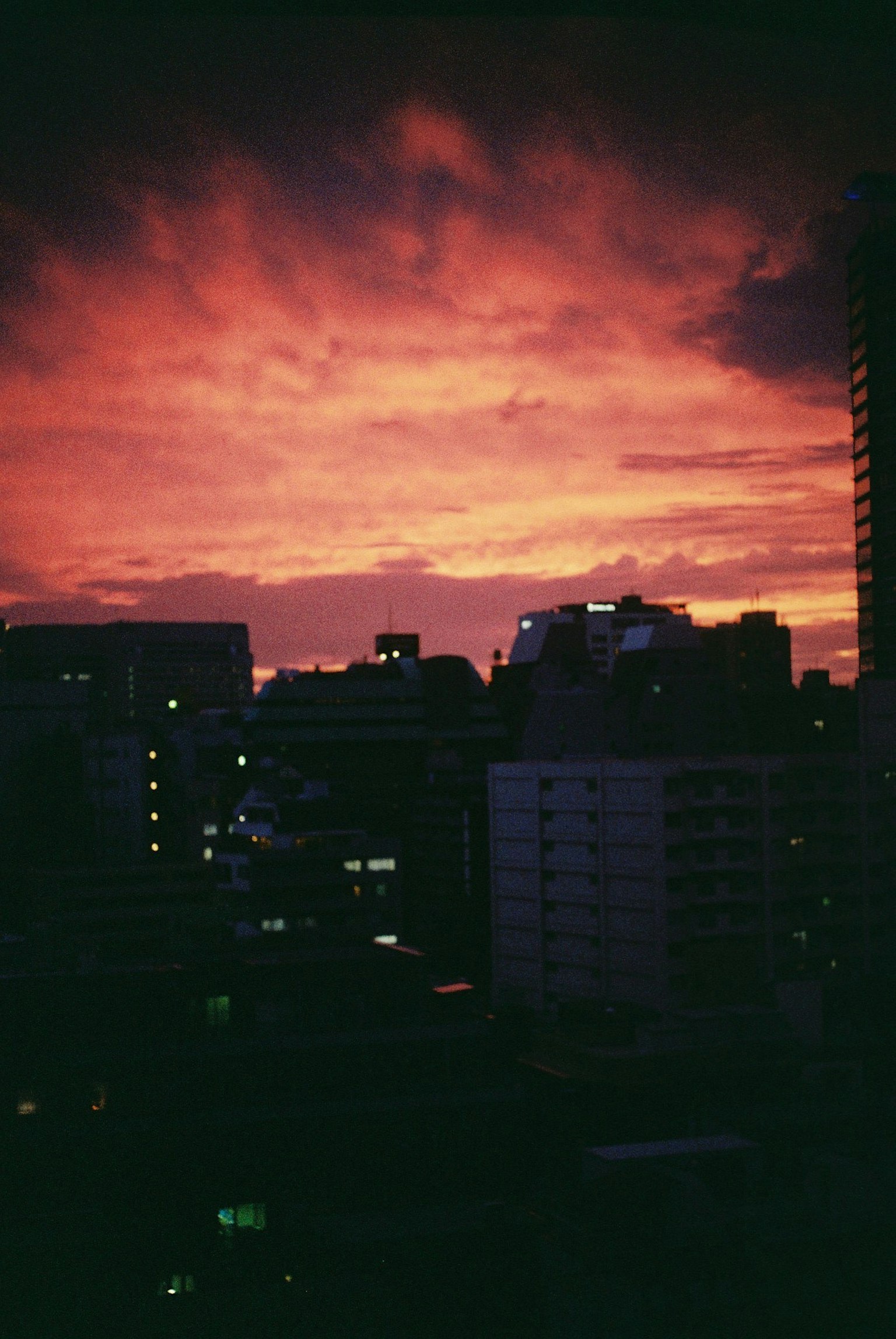 City skyline at sunset with vibrant orange and purple clouds