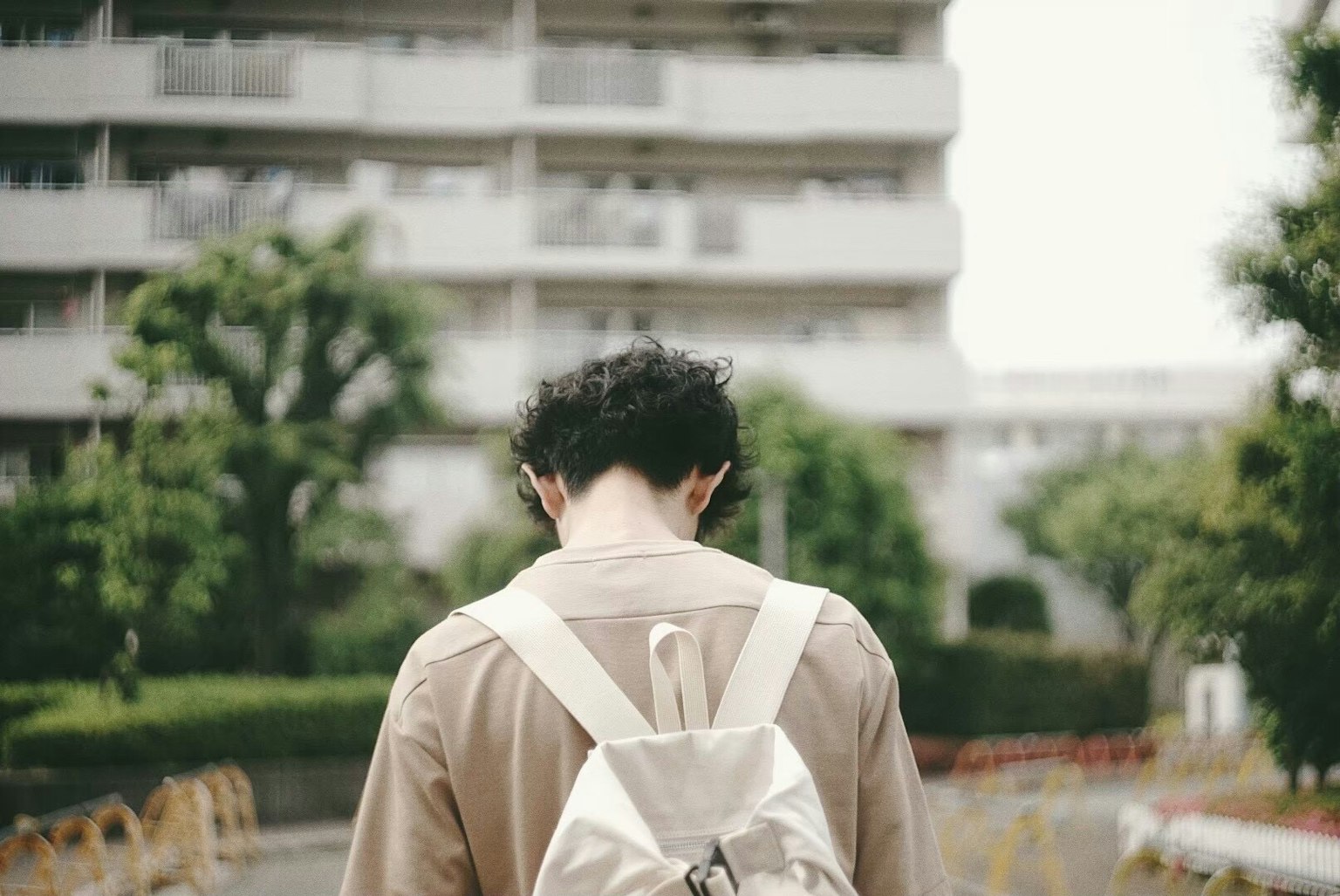 배낭을 메고 걷는 젊은이와 주거 지역