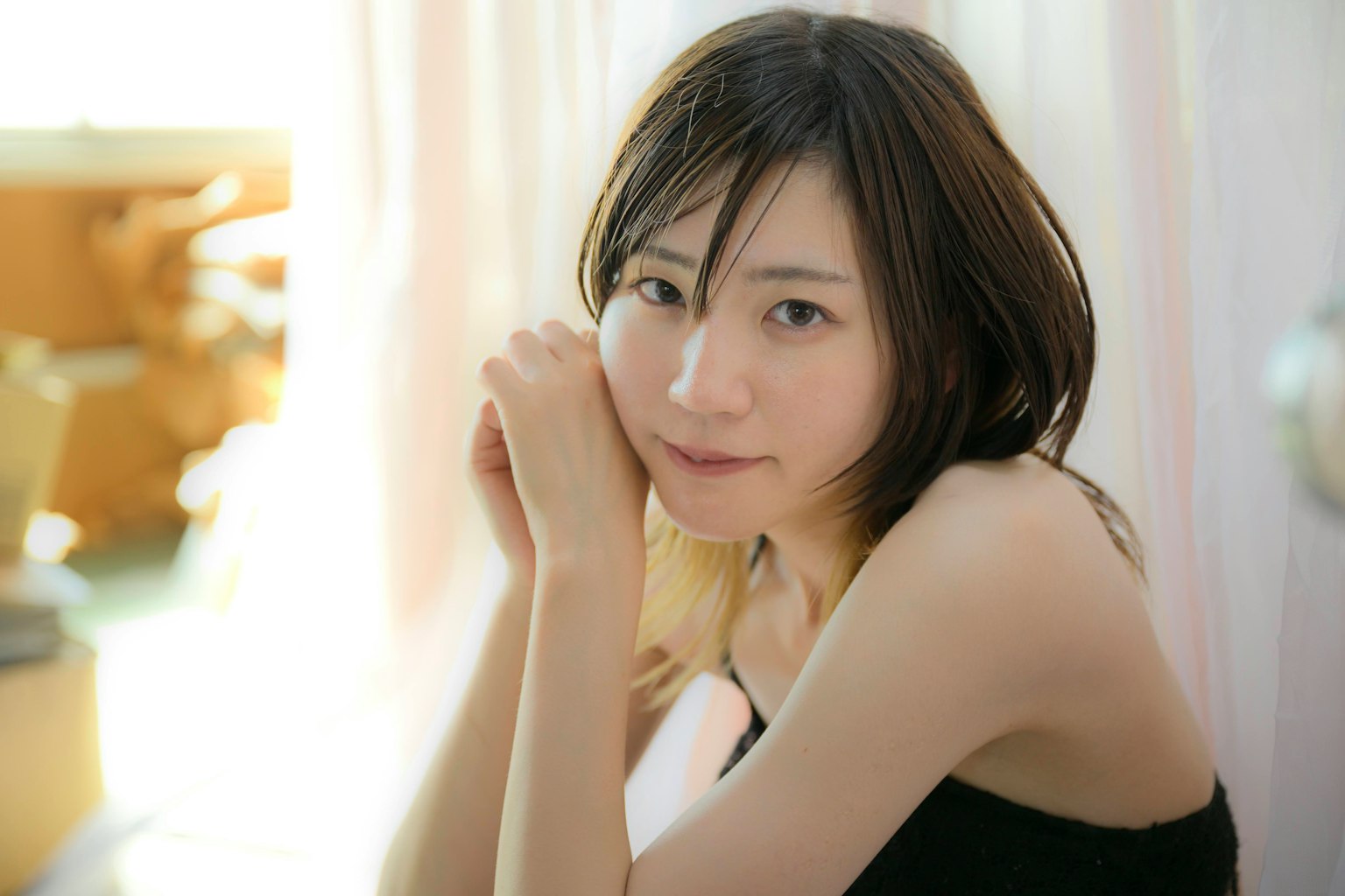 편안한 표정의 여성이 손을 얼굴에 대고 있는 장면