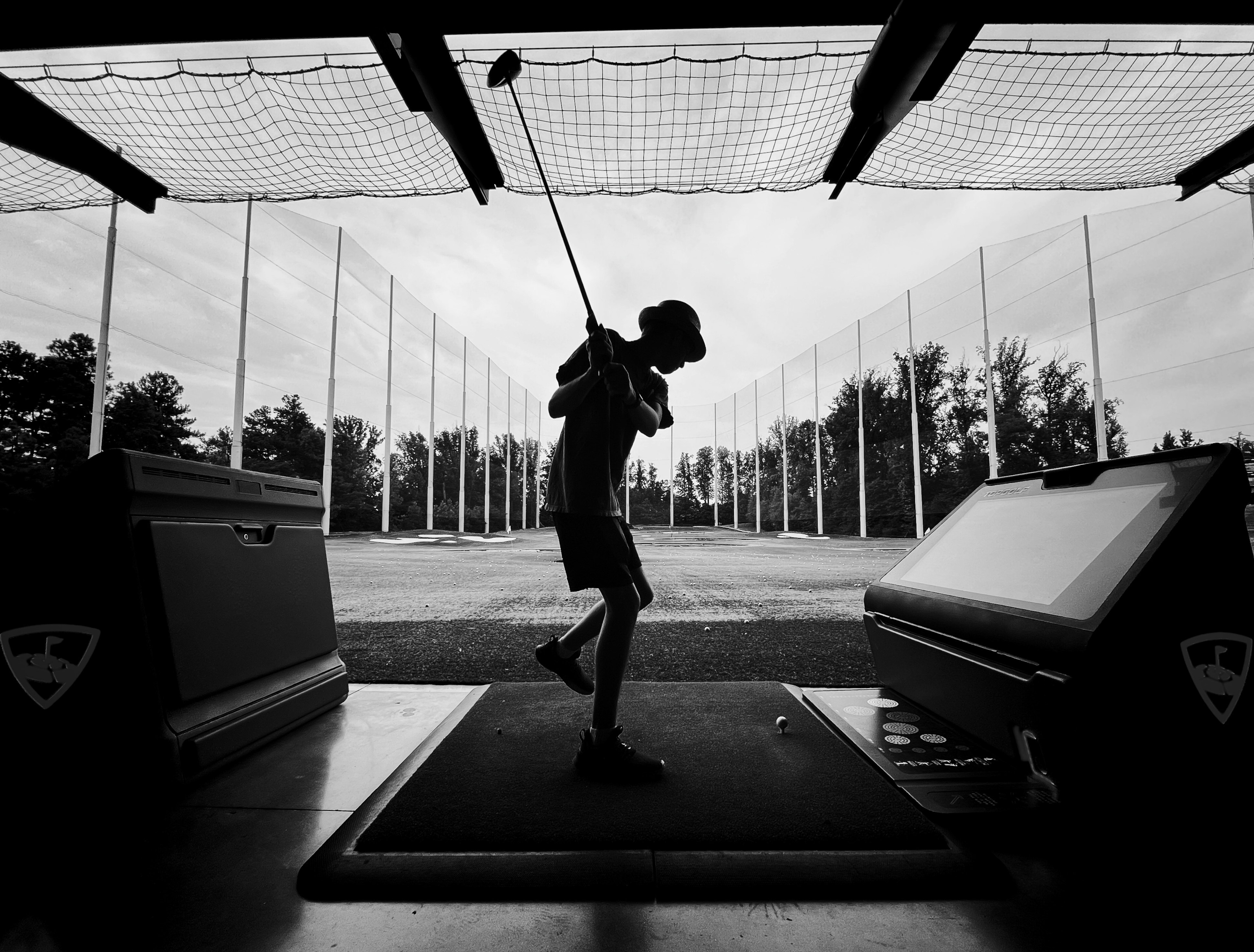 Golfspieler in Pose auf einer Outdoor-Driving-Range, Gegenlicht