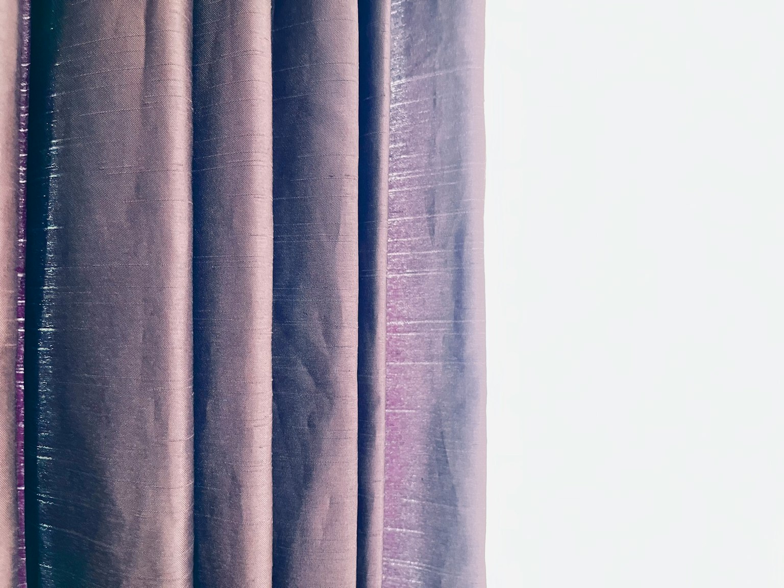Texturierte Vorhänge, die an einem hellen Fenster hängen