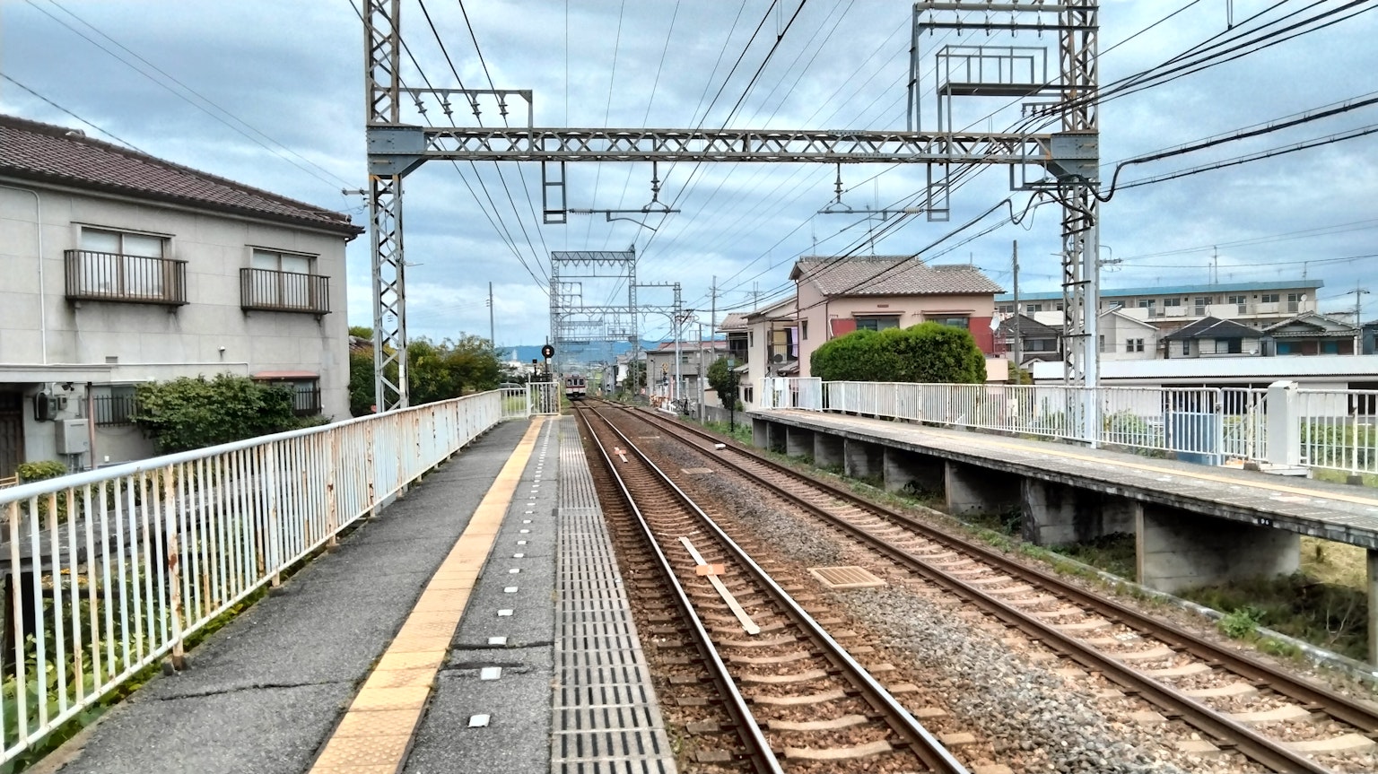 Vue d'une plateforme de gare et des voies ferrées