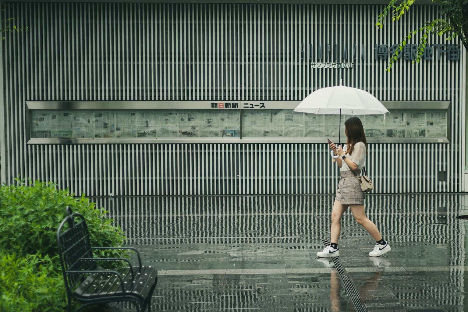 Eine Frau, die mit einem Regenschirm im Regen geht