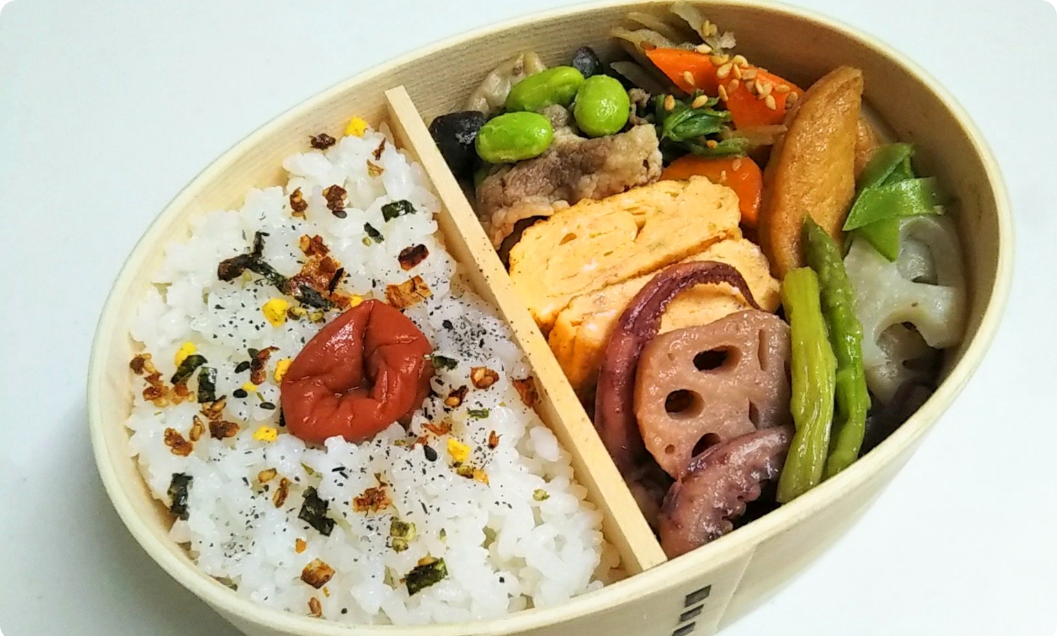 밥, 계란말이, 채소, 구운 생선이 담긴 도시락
