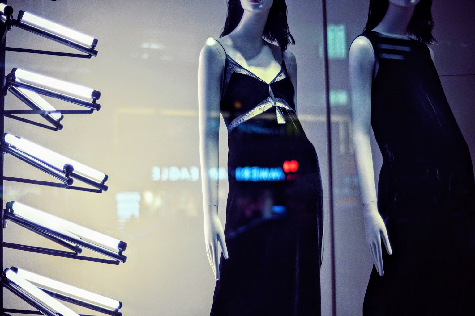 Image de mannequins portant des robes noires dans une vitrine élégante