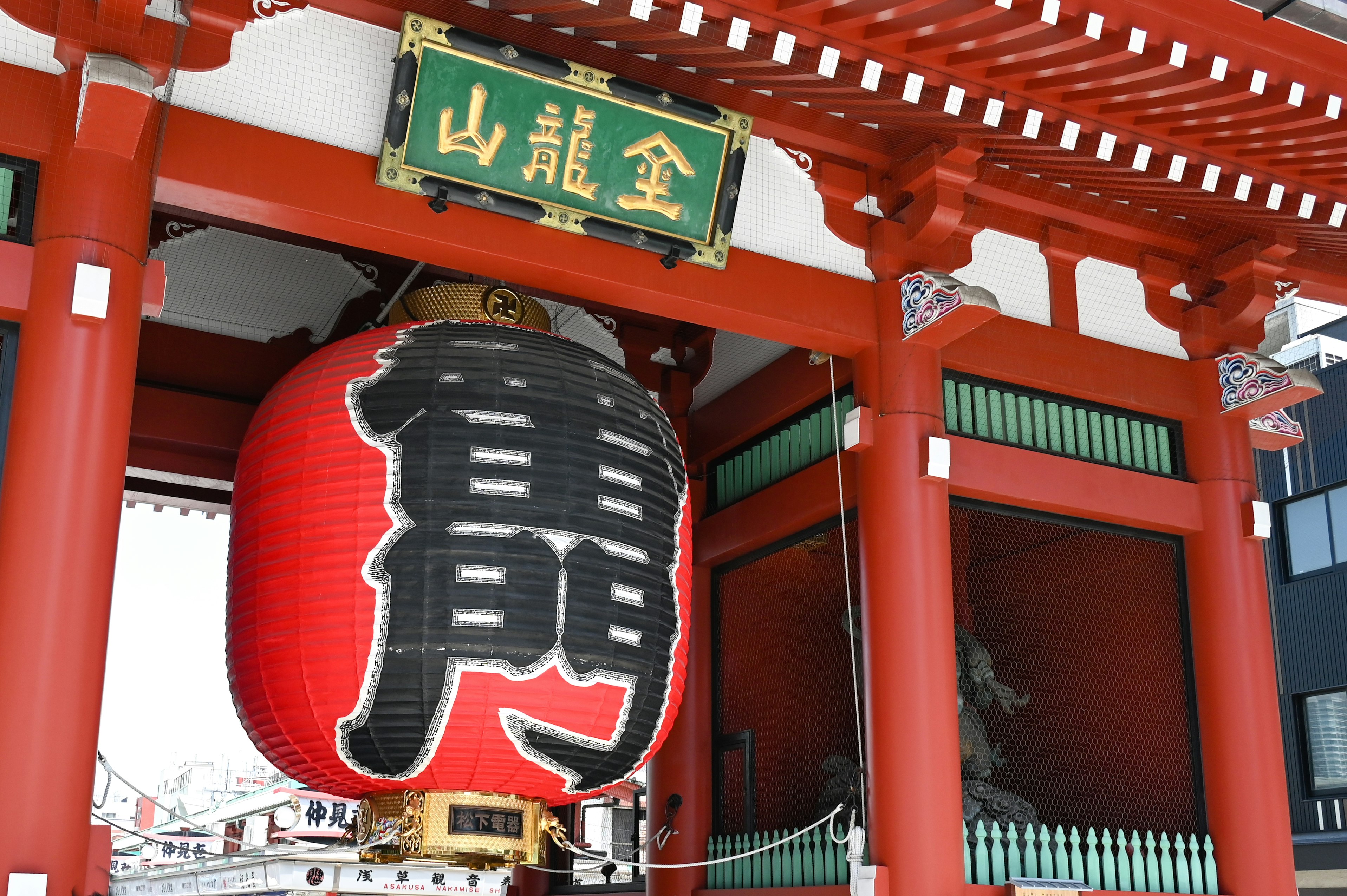 紅色鳥居下的神社入口，懸掛燈籠與招牌