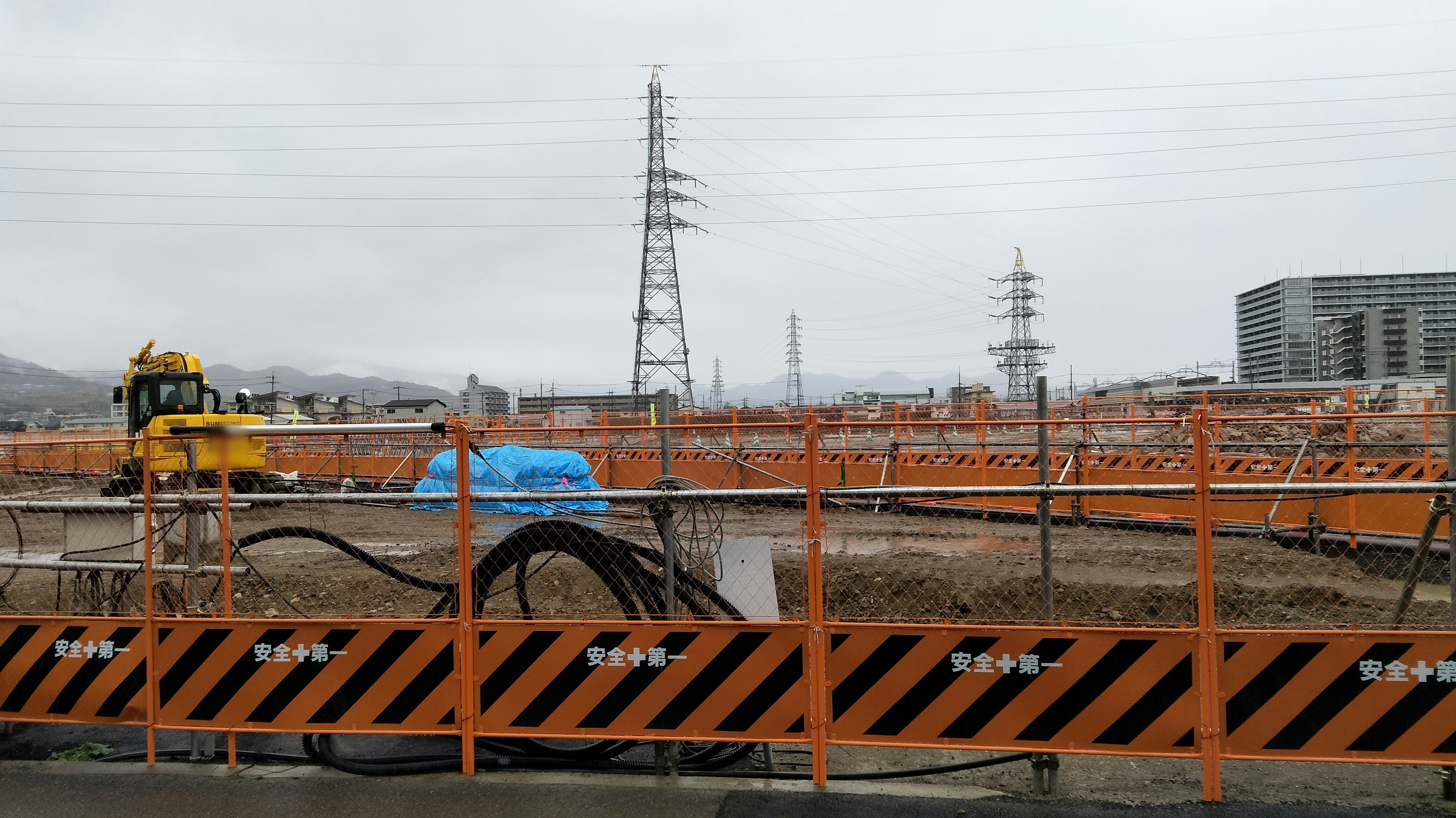 construction site with safety fencing, pipes and machinery