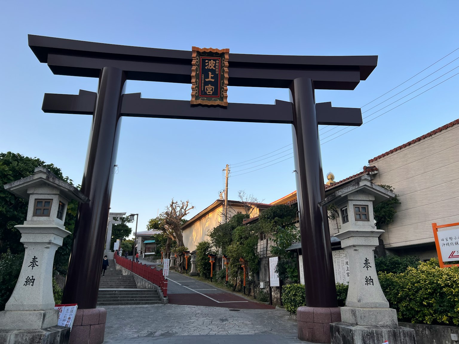 Eingang mit einem schwarzen Torii und Steingeländern