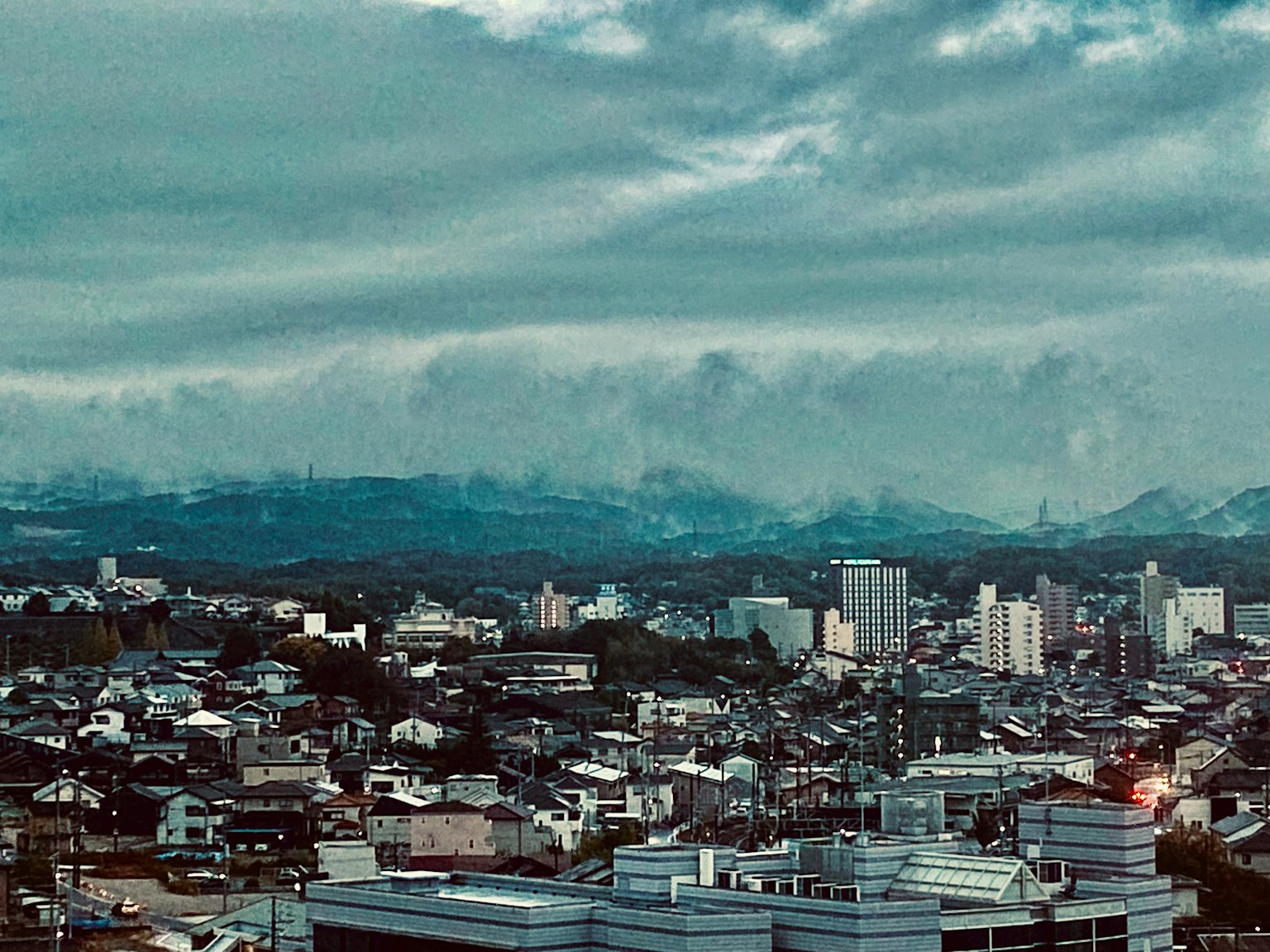 Paysage urbain avec des bâtiments sous un ciel nuageux et des montagnes en arrière-plan