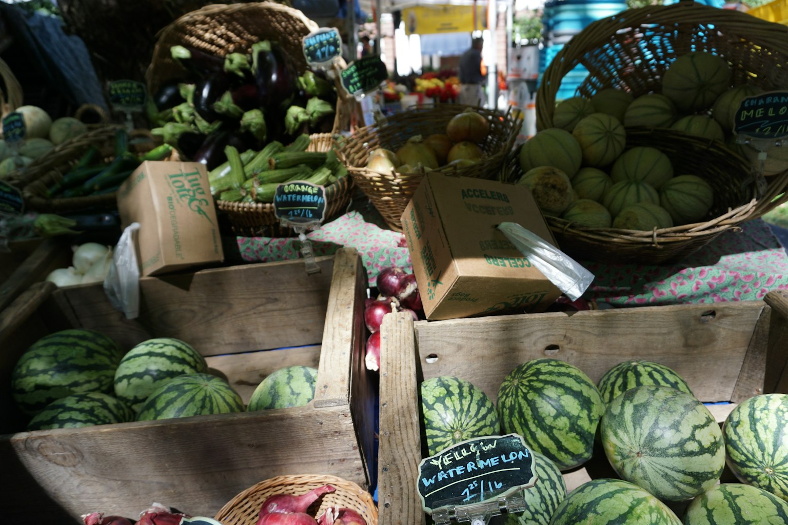 Scena di mercato vivace con vari frutti e verdure cesti di angurie e meloni in casse di legno