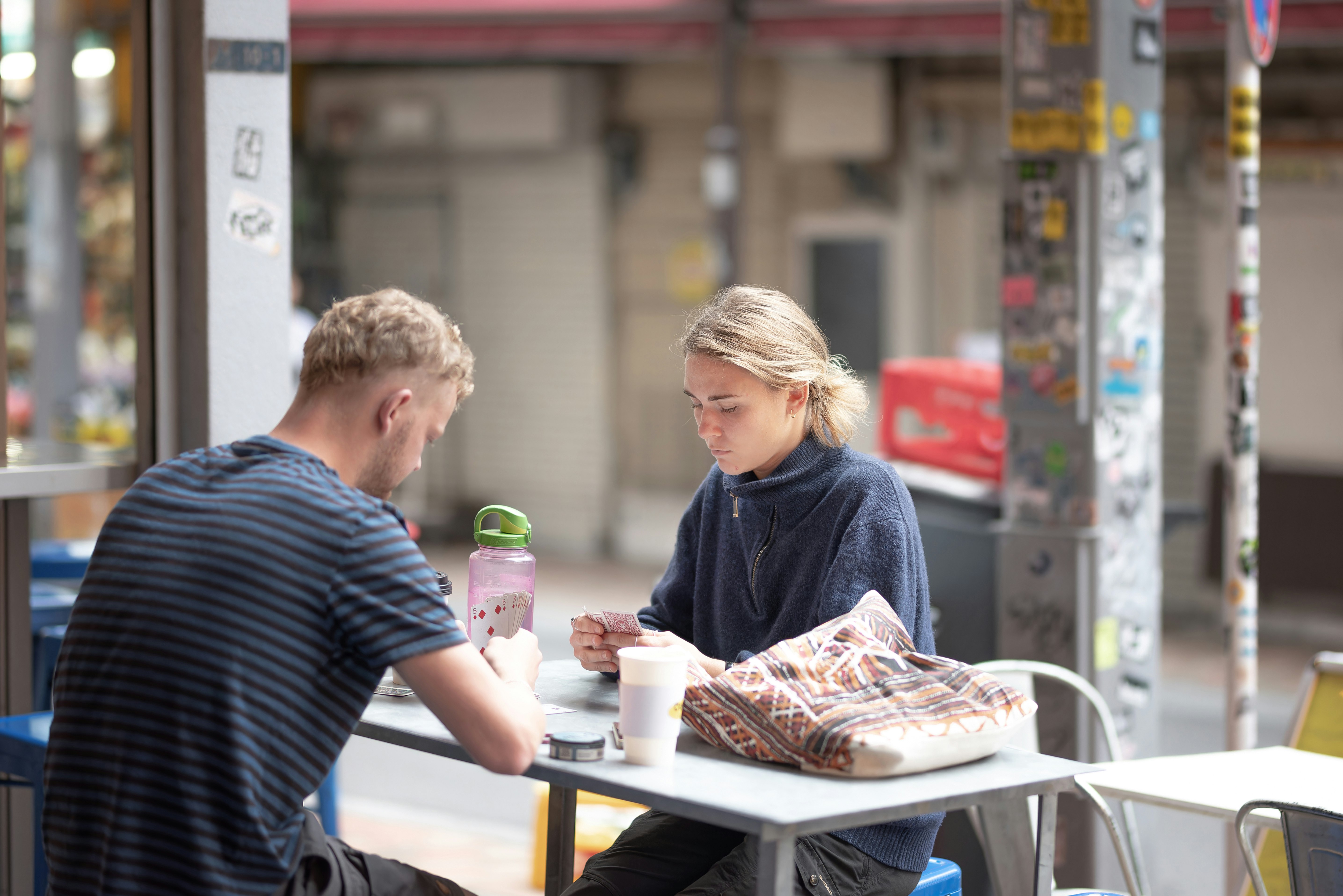 路上のテラス席で食事をする男女