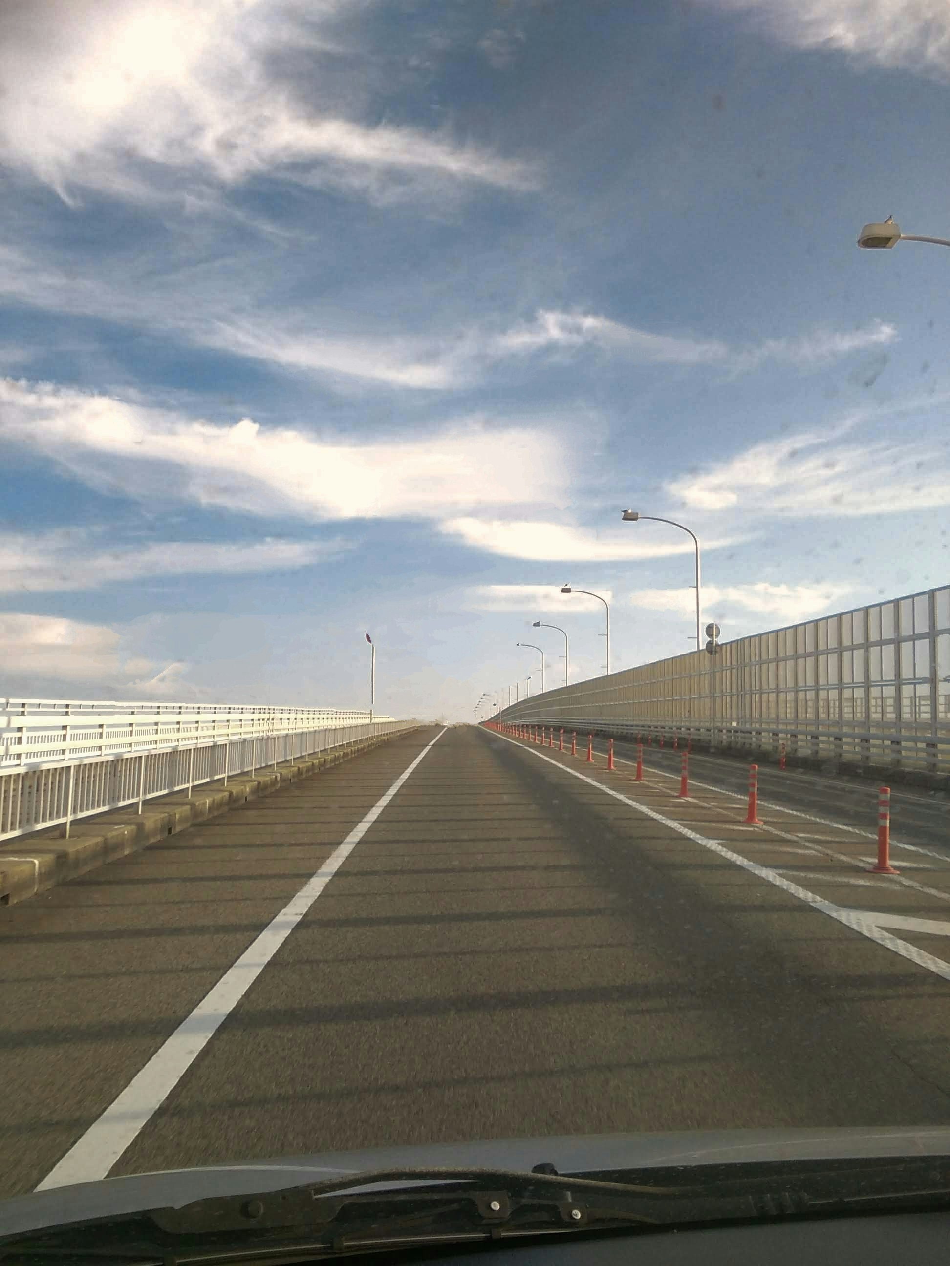 ドライブ中の道路と青空の雲、白線のある直線の道