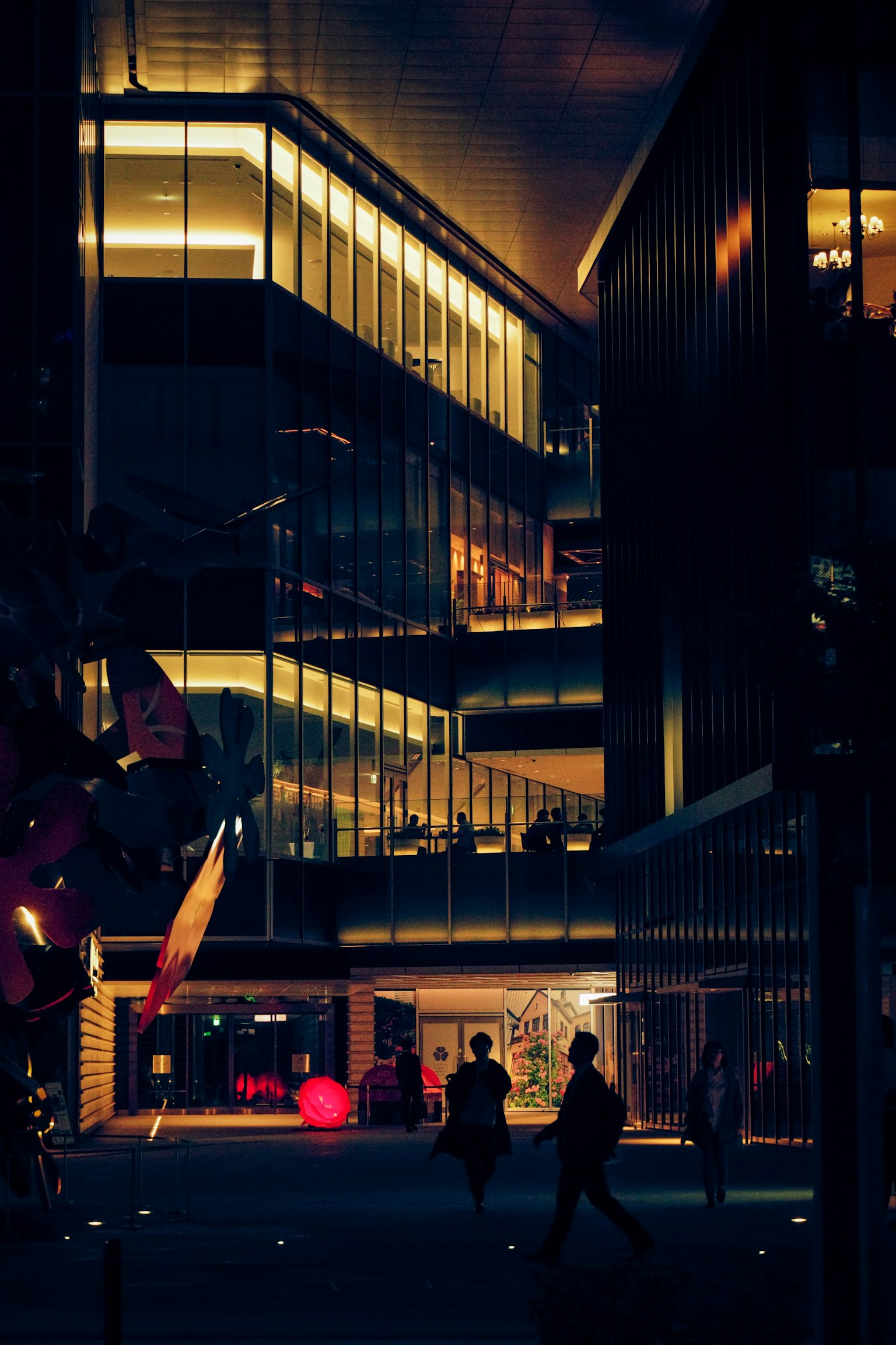 Urban night scene with modern buildings and people walking