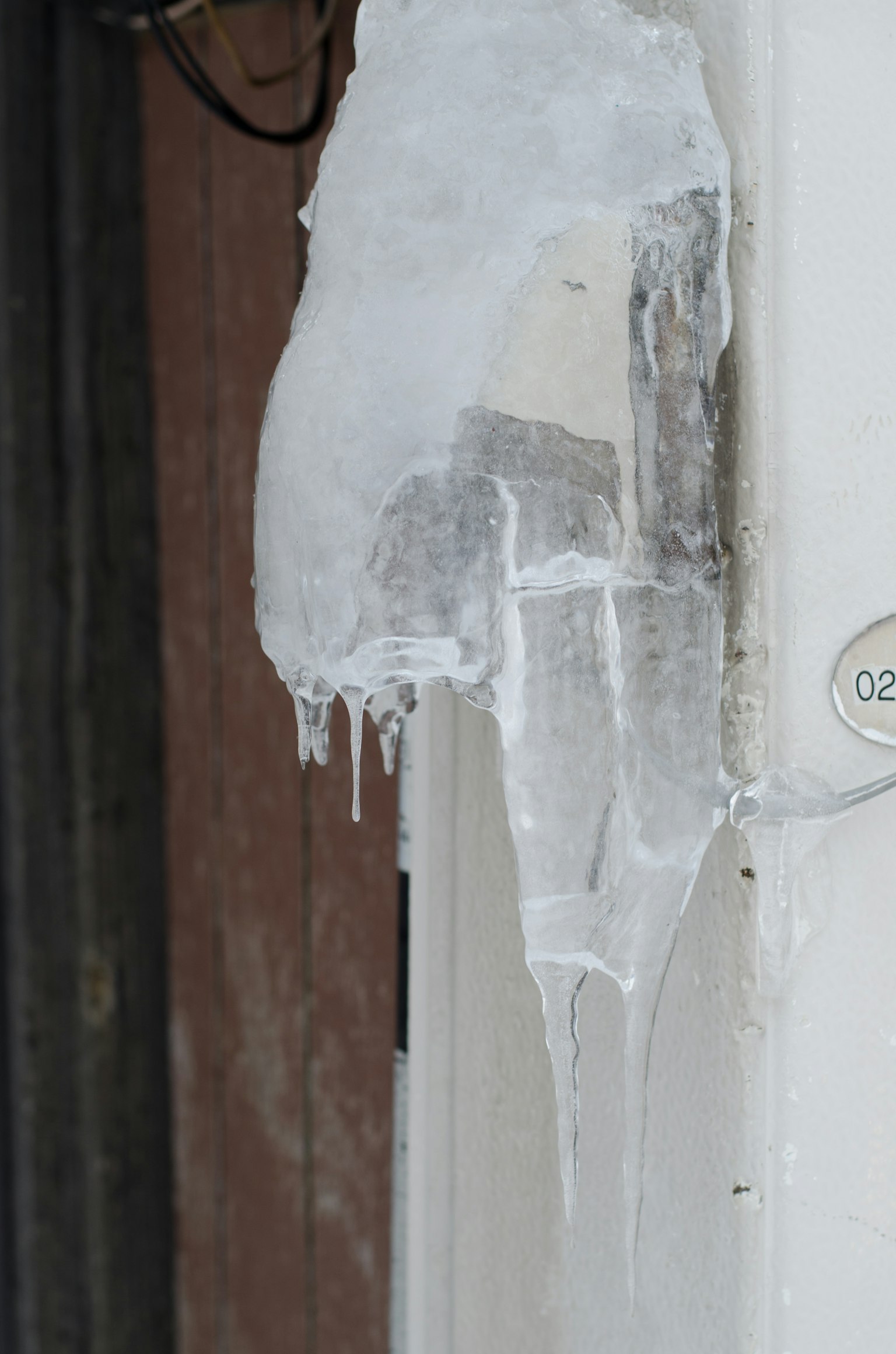 Eiszapfen hängt in der Nähe einer Tür