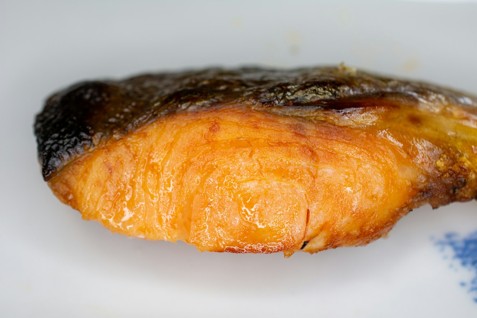 烤鮭魚片的特寫，展示了焦邊和橙色魚肉