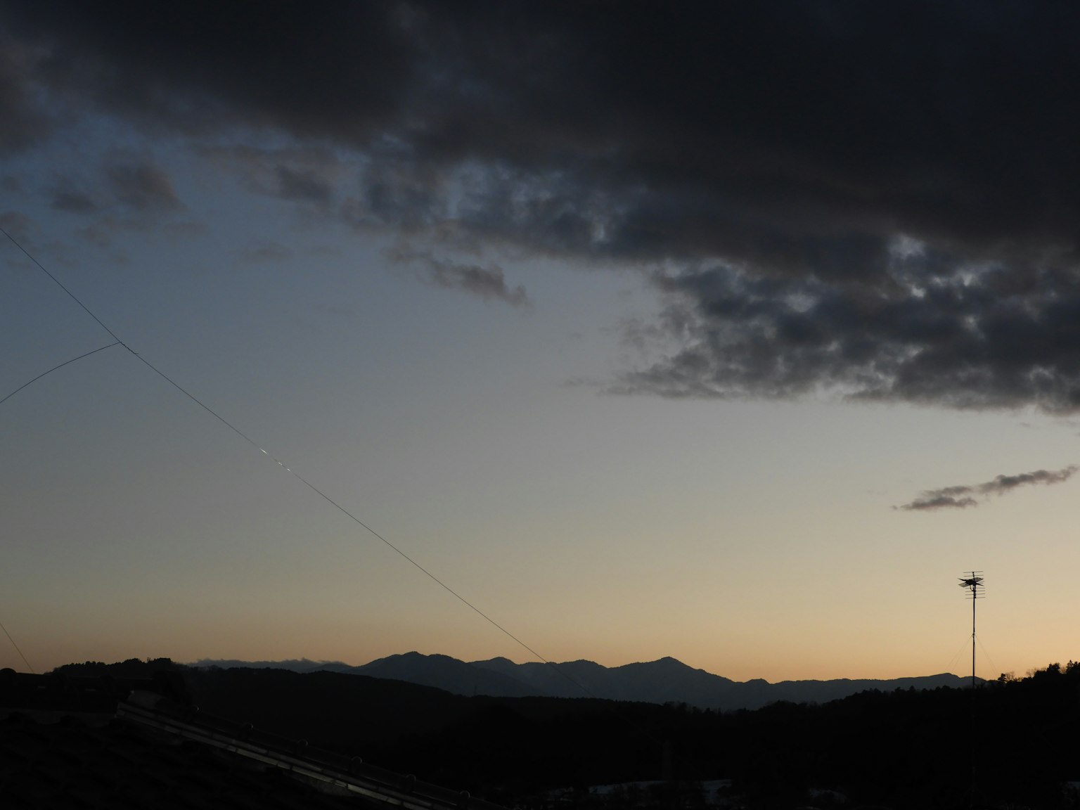 黃昏天空中散布的雲和山的輪廓